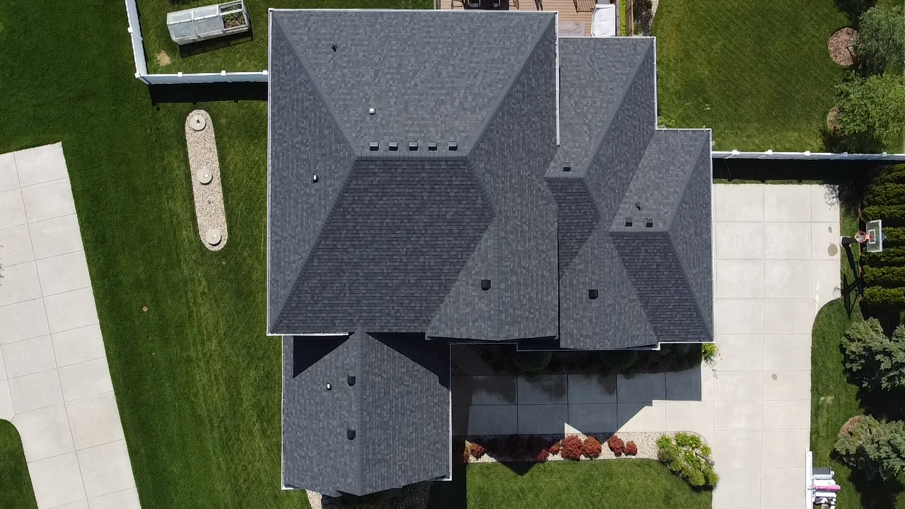 Top-down drone view of a residential roof with multiple roof planes finished in Owens Corning Duration Flex Onyx Black shingles.
