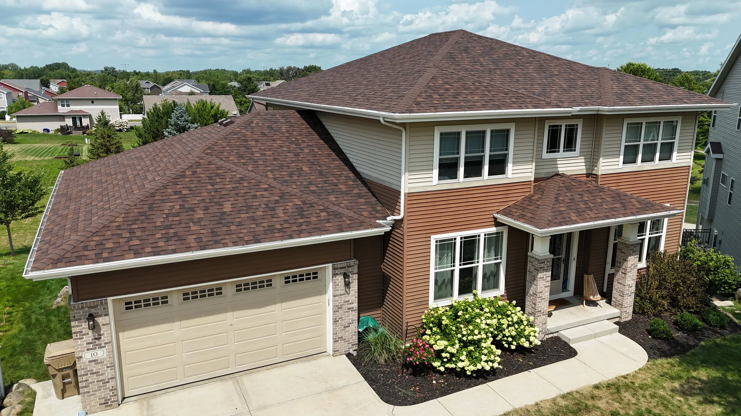 Front aerial view of a two-story home with an Owens Corning Duration Brownwood shingle roof.