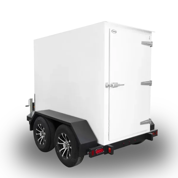 White insulated trailer with black wheel fenders and double doors at the back, mounted on a dual-axle trailer with black and chrome wheels, utilized for refrigerated transport.