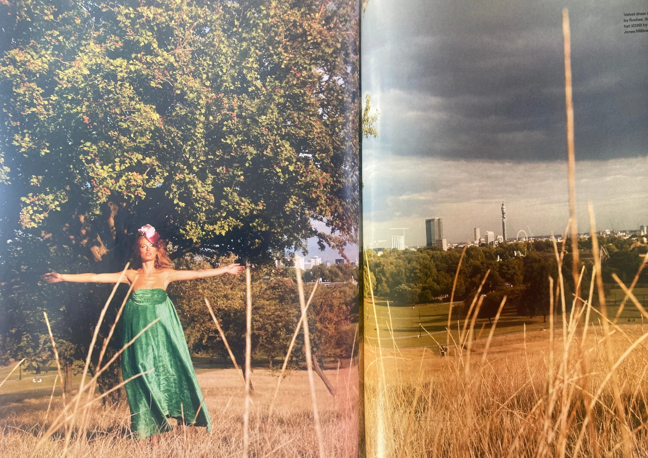 Double page fashion editorial from ELLE UK December 2003 showing a white woman with long blonde hair wearing a full length green dress and pink head piece standing in a field.