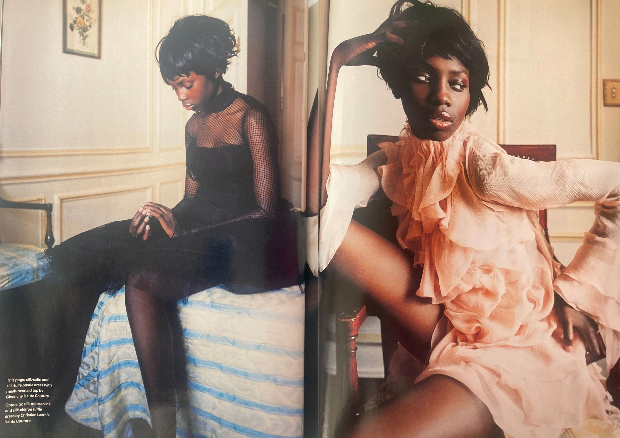 Double page fashion editorial from ELLE UK December 2003 showing a black woman with short hair wearing a black mesh dress on the left and a pink ruffle dress on the left.