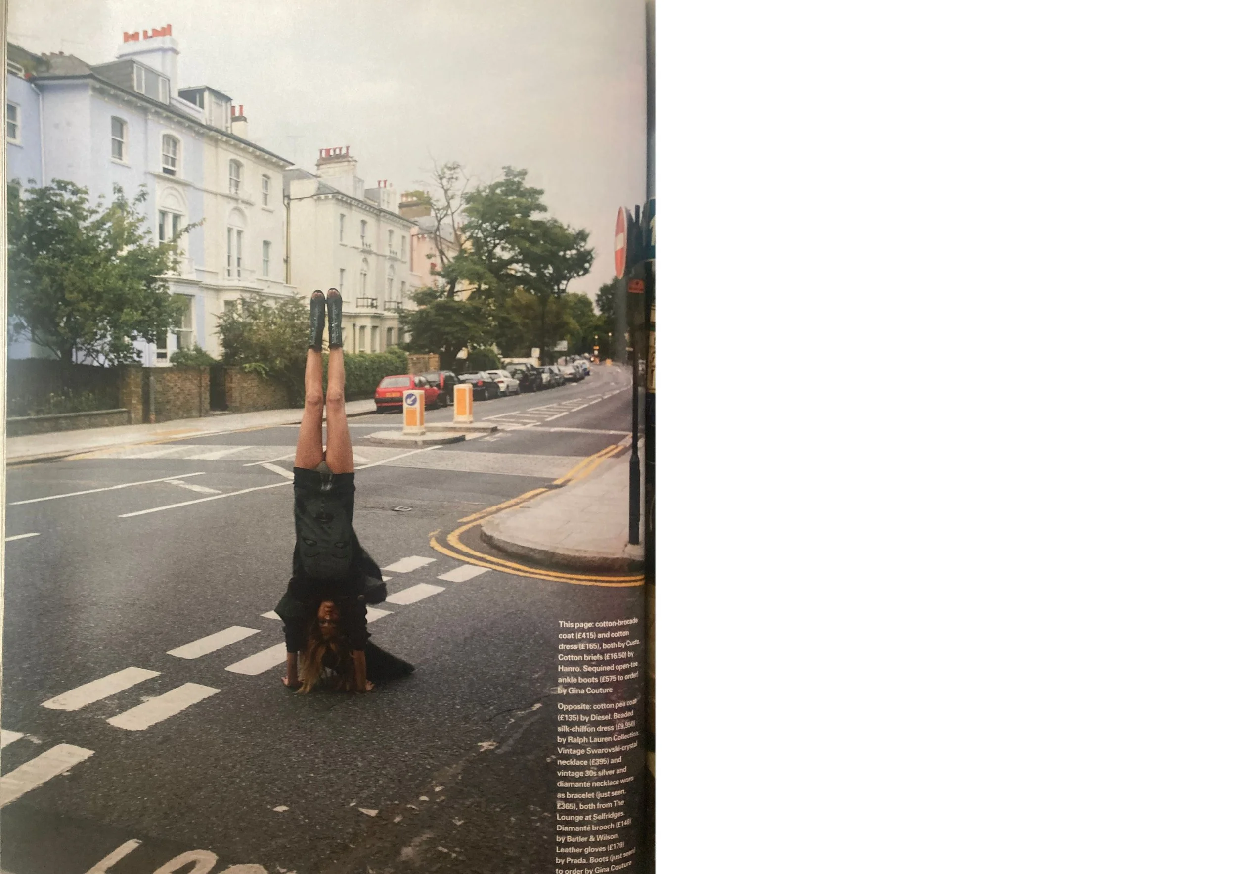 Double page fashion editorial from ELLE UK December 2003 showing a white woman with long blonde hair wearing and an black outfit whilst doing a headstand