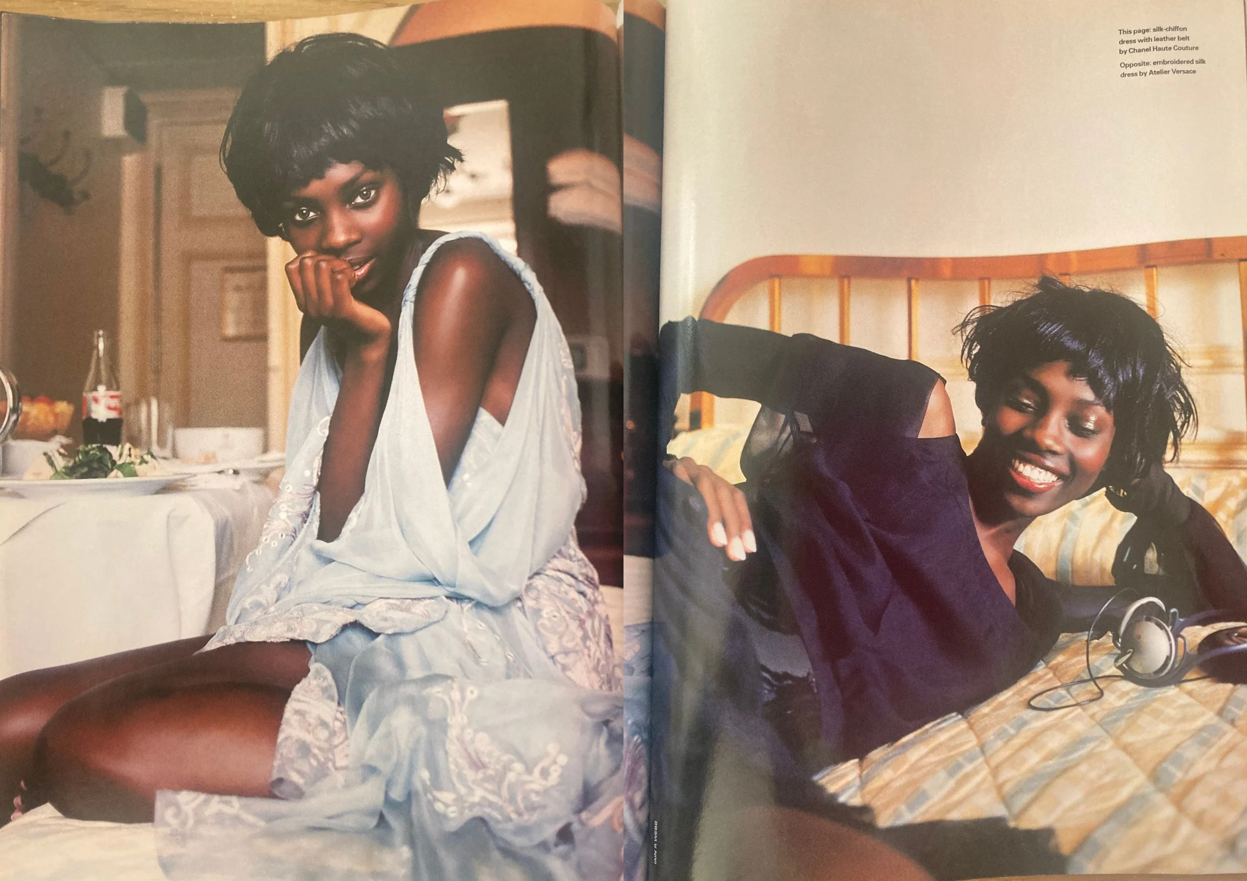 Double page fashion editorial from ELLE UK December 2003 showing a black woman with short hair wearing a light blue dress on the left and a black top and skirt on the right