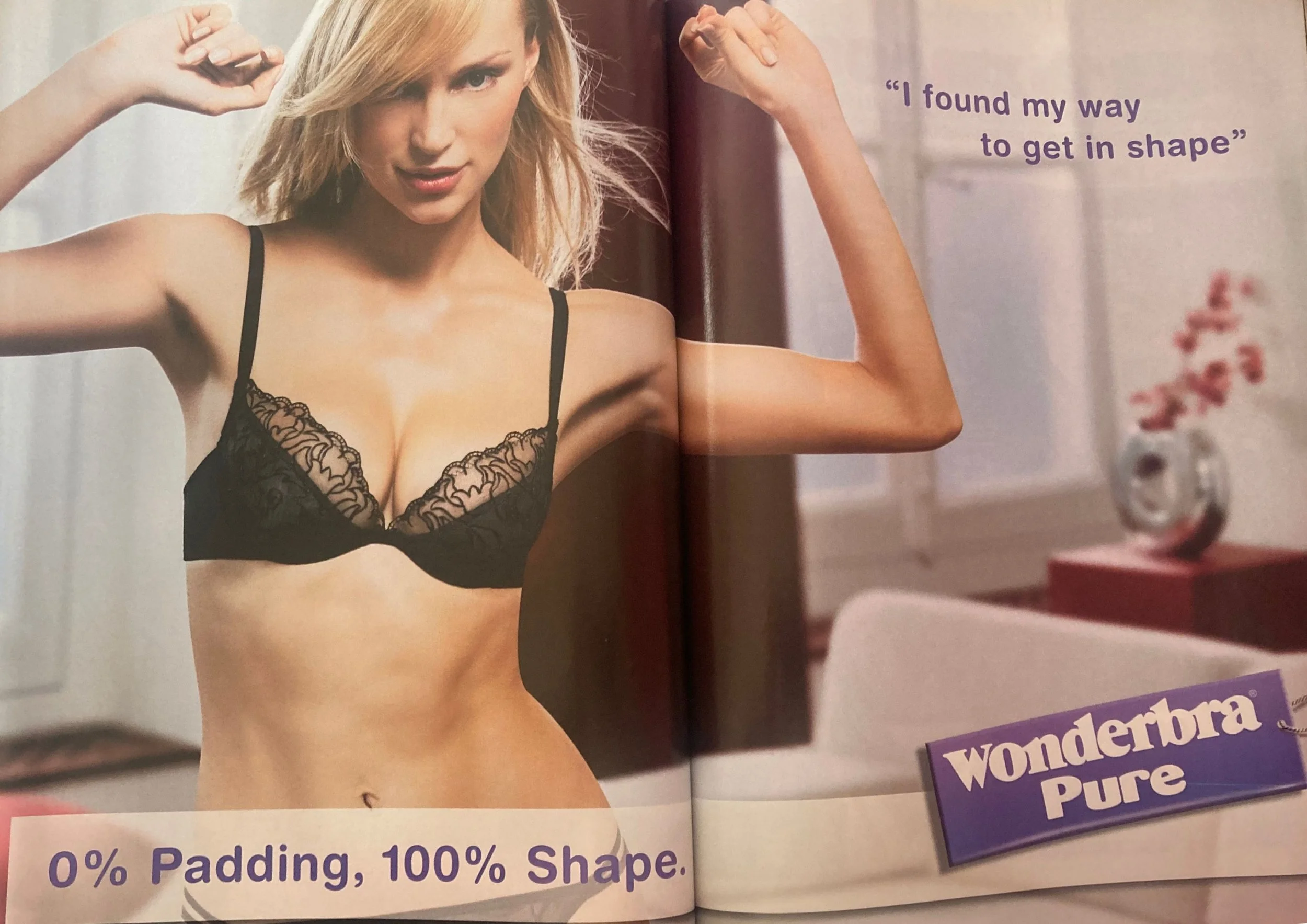 Double page advert featuring a white woman with blonde hair posing in a black lace bra