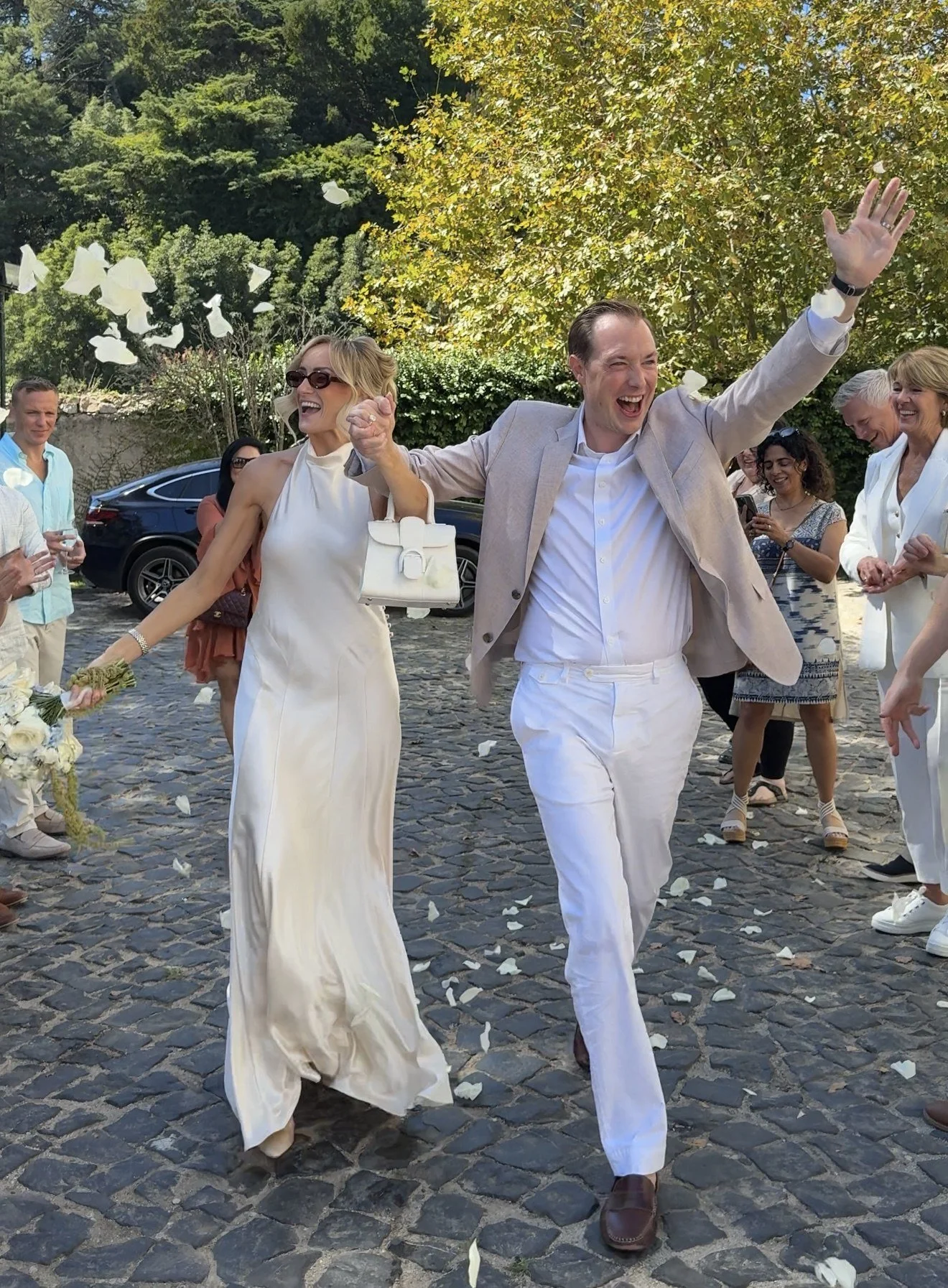Jeni and Trevor leaving through a shower of petals