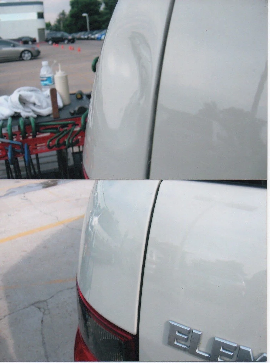 Side view of a white car, showing the rear section with an emblem that reads 'ELF'. The car is parked, with a parking lot surface and some other cars in the background.