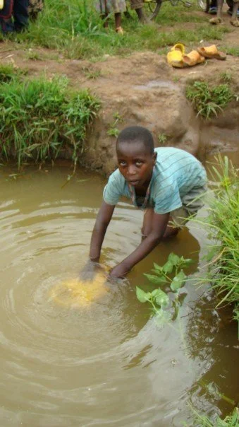 Boy filling jug Rwanda.jpg