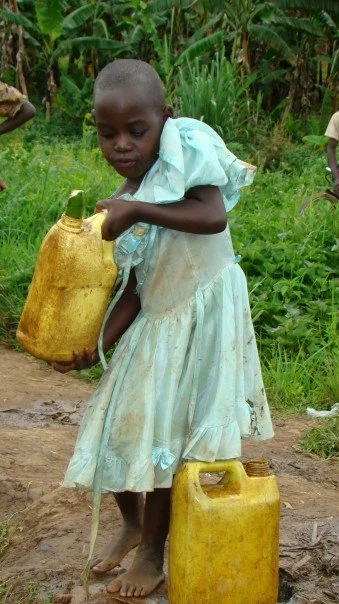 Girl with water jugs Rwanda.jpg