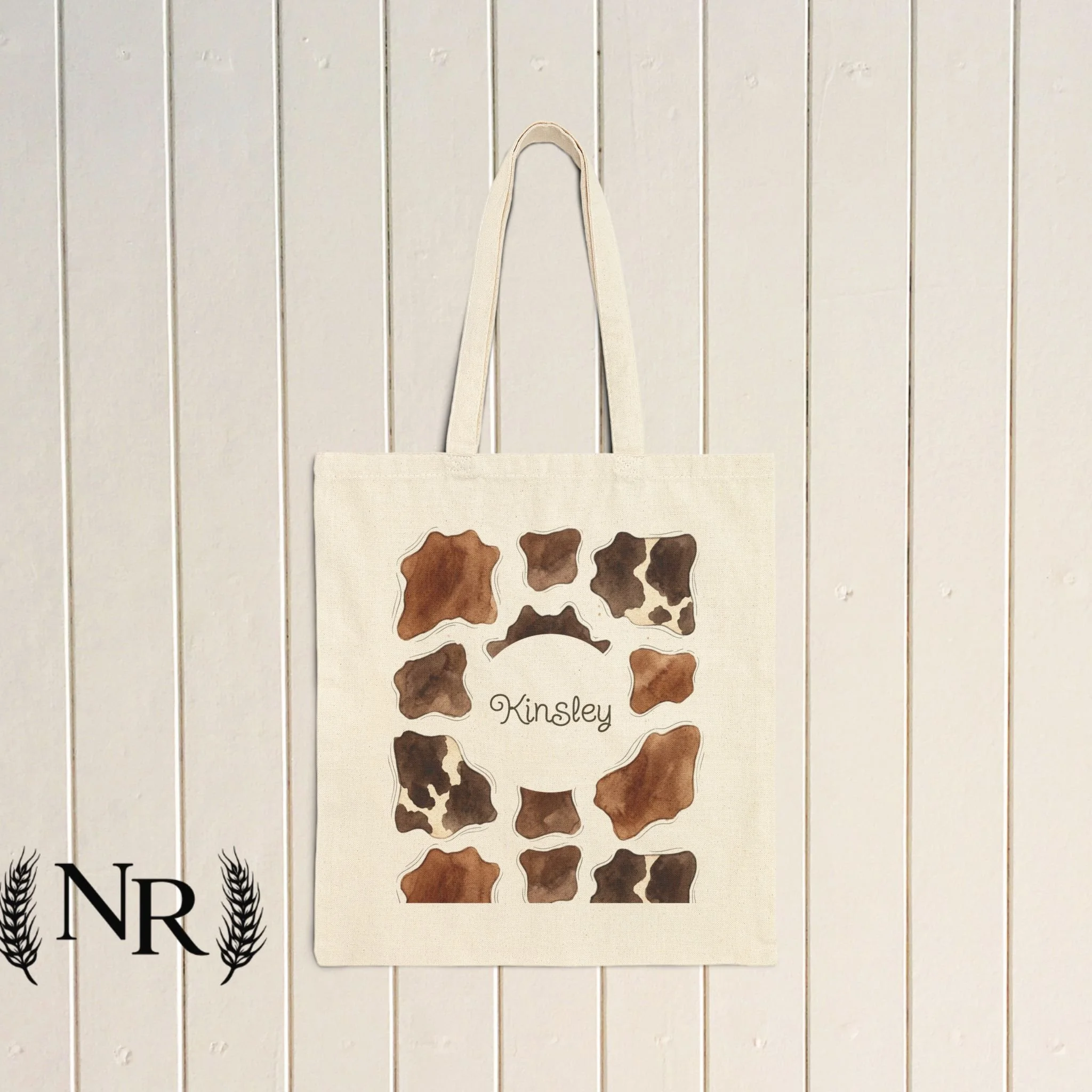 A cotton canvas tote with a soft, natural look—features warm, watercolor-like cowprint with space to personalize! Add your name or other fun texts to make this unique for you.