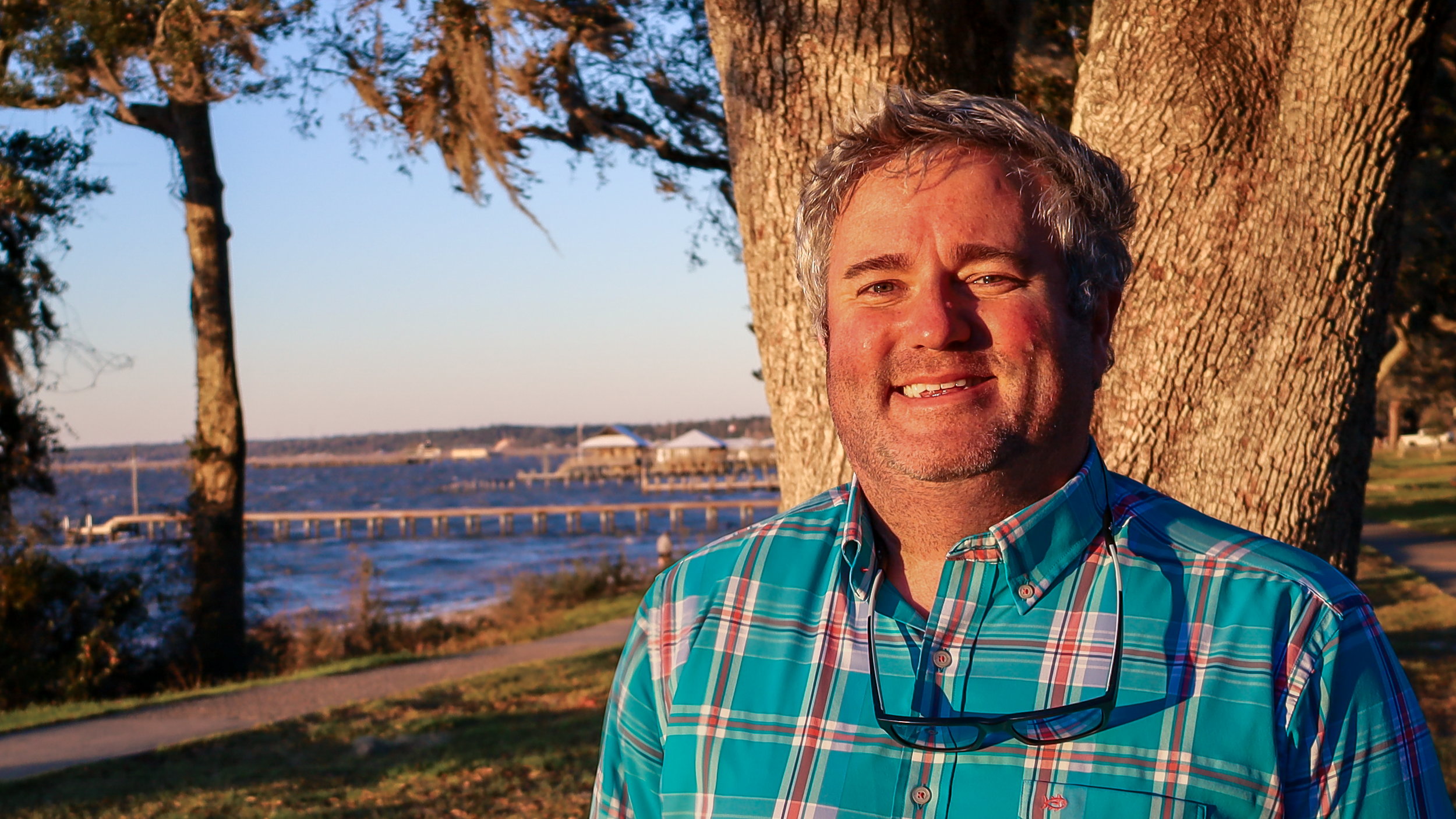 Timmy Marrinan, counselor in Chandler, Arizona, standing beneath an oak tree along the waterfront.