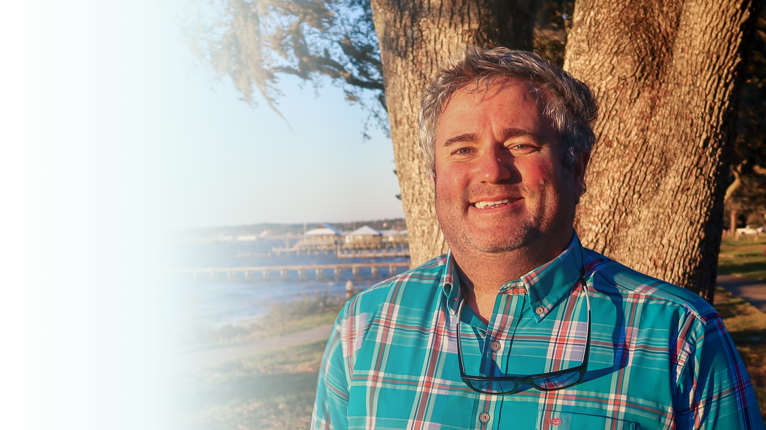 Timmy Marrinan, counselor in Chandler, Arizona, standing beneath an oak tree along the waterfront.