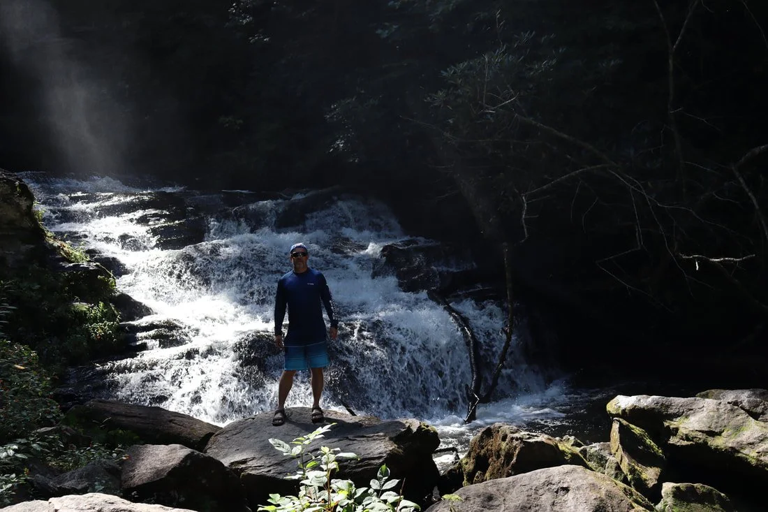 owner standing next to waterfall