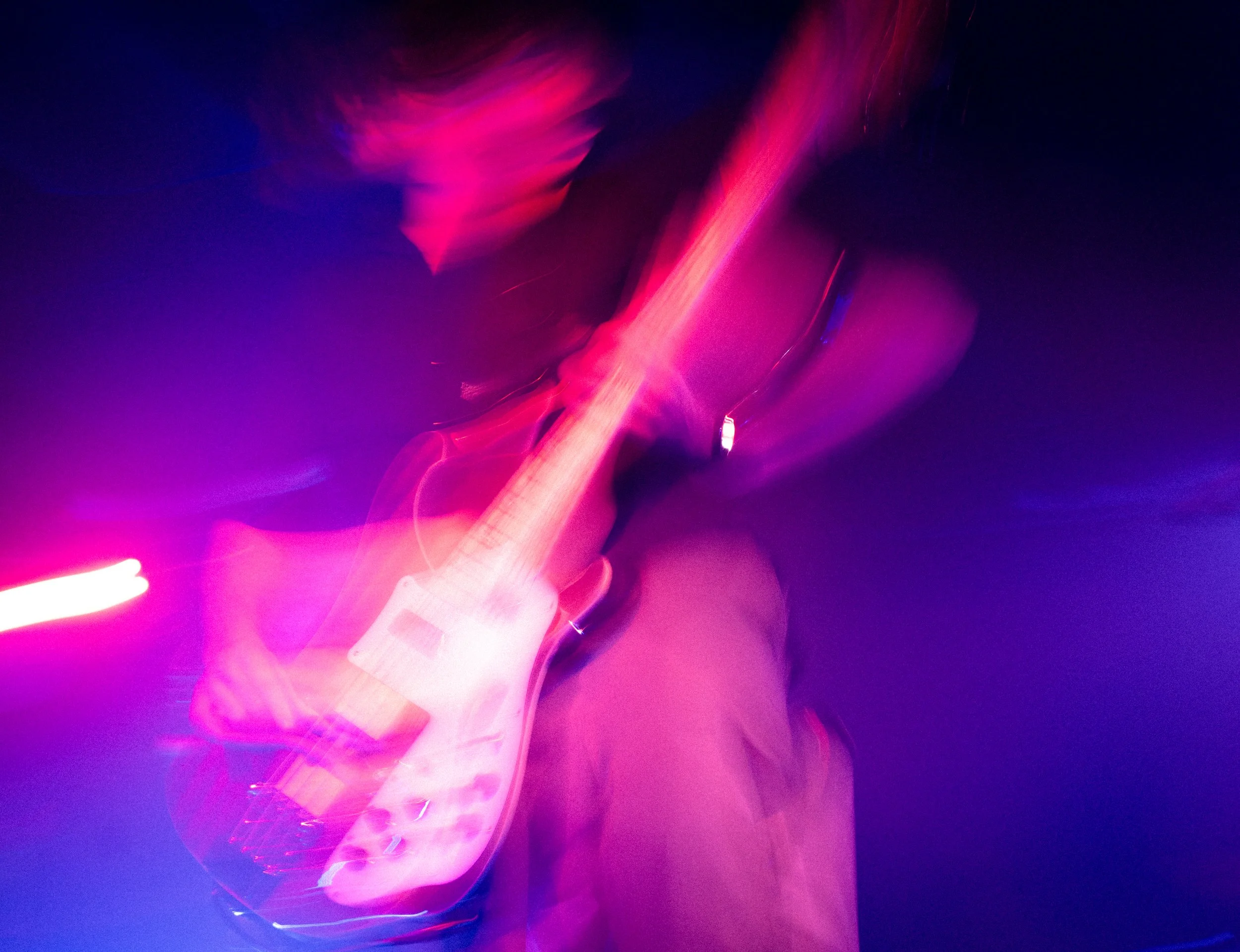 Abstract digital artwork with vibrant pink, purple, and blue light streaks and blurry motion effects.