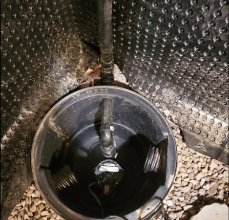 Picture of a sump pump pit installed in a basement after weeping tile disconnection.