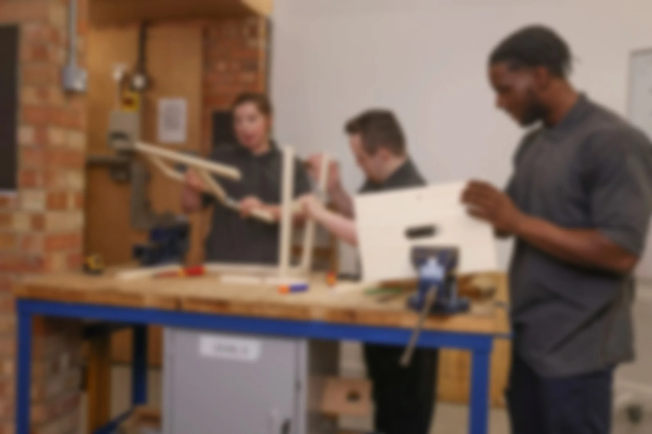 Participants assembling a wooden piece as part of a hands-on session