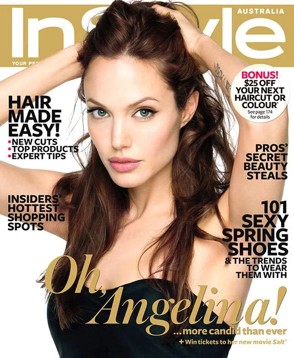 A woman with long brown hair and blue eyes posing on the cover of InStyle magazine, Australia edition, with her hand touching her head. The cover features headlines about hair styling, beauty tips, shoes, and Angie. She is wearing a black top.