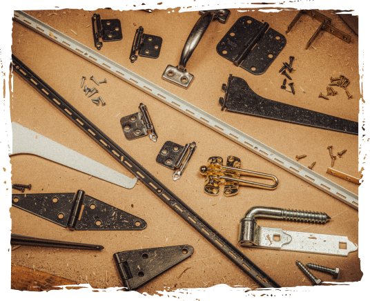 Various disassembled metal hardware parts and tools on a workbench, including hinges, brackets, screws, and rulers.