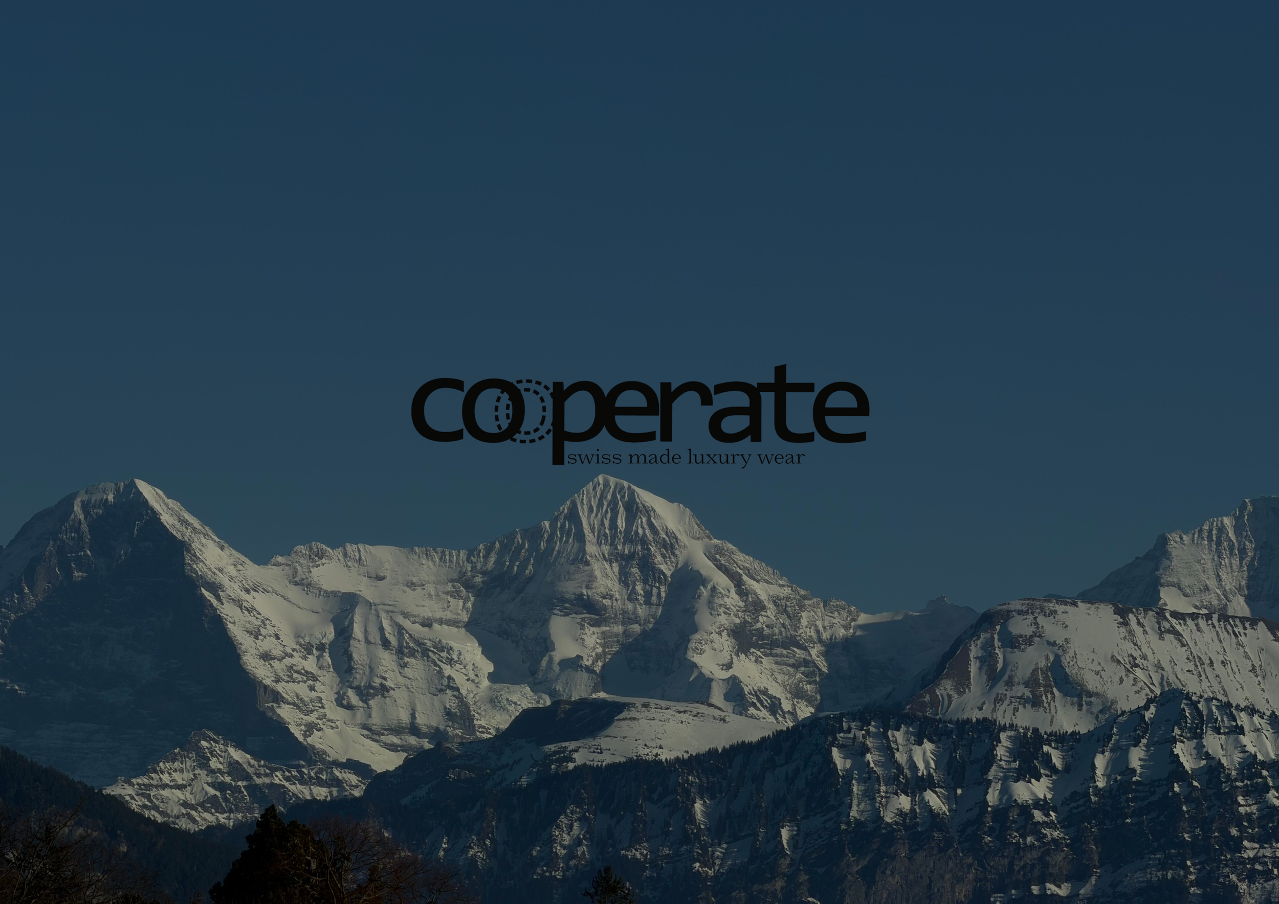 Berglandschaft mit schneebedeckten Gipfeln und klarem Himmel, mit dem Logo und dem Schriftzug "cooperate - swiss made luxury wear" in der Bildmitte.