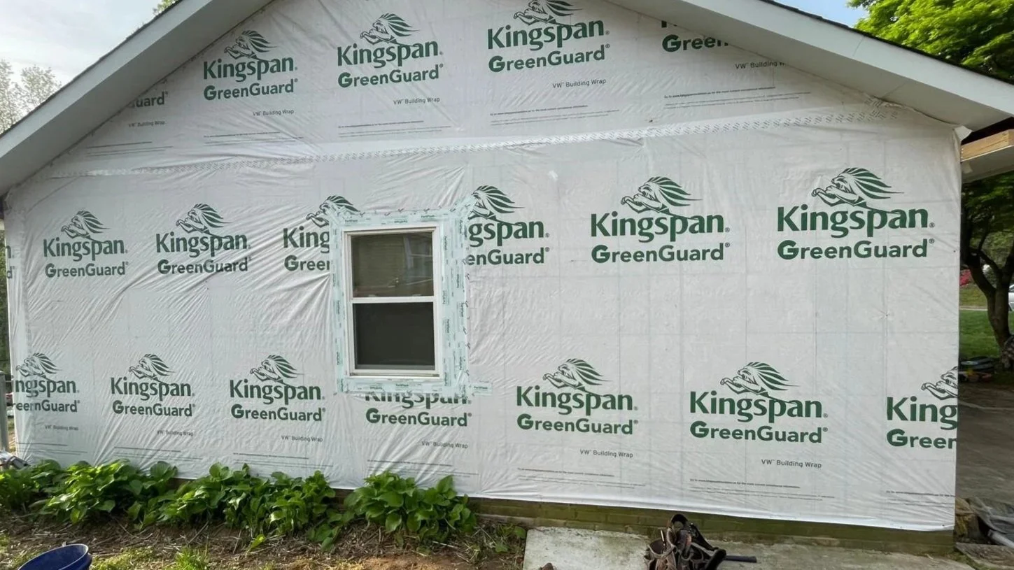 Oakstone Exteriors crew preparing a local residential home for new siding installation using high-quality house wrap moisture barrier.