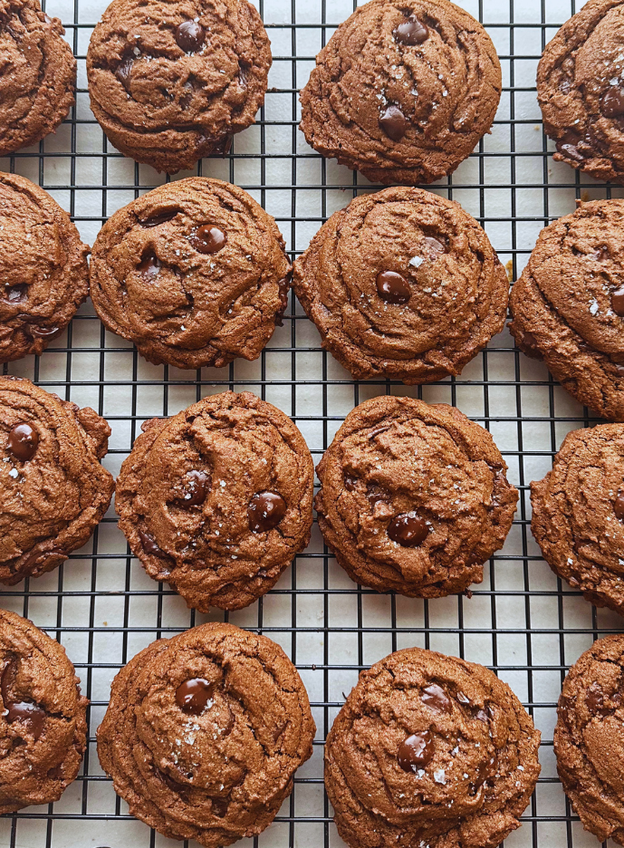 Chocolate chip cookies cooling on a wire rack.