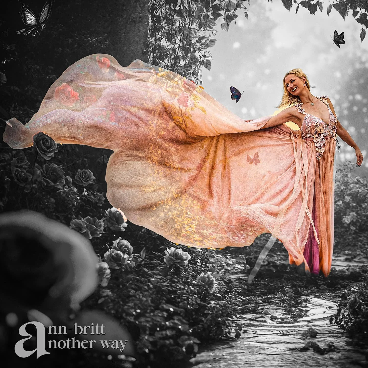 Woman in a peach flowing dress smiling while standing in a stream with dark trees and butterflies around her, with the words 'an other way' in the bottom left corner.