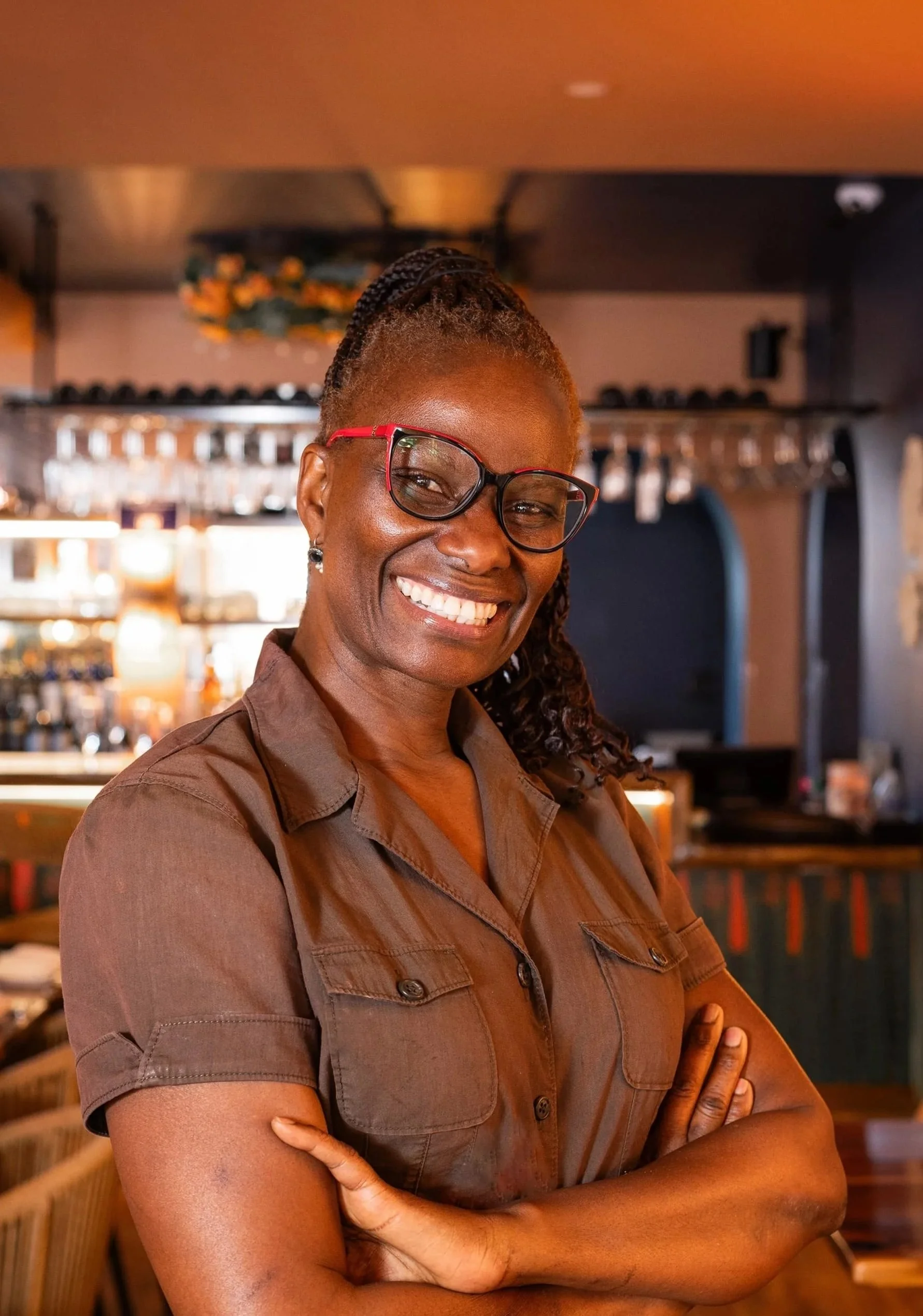 Co-owner, Martha Addison, stands with arms crossed at the Bistro SOJO bar.