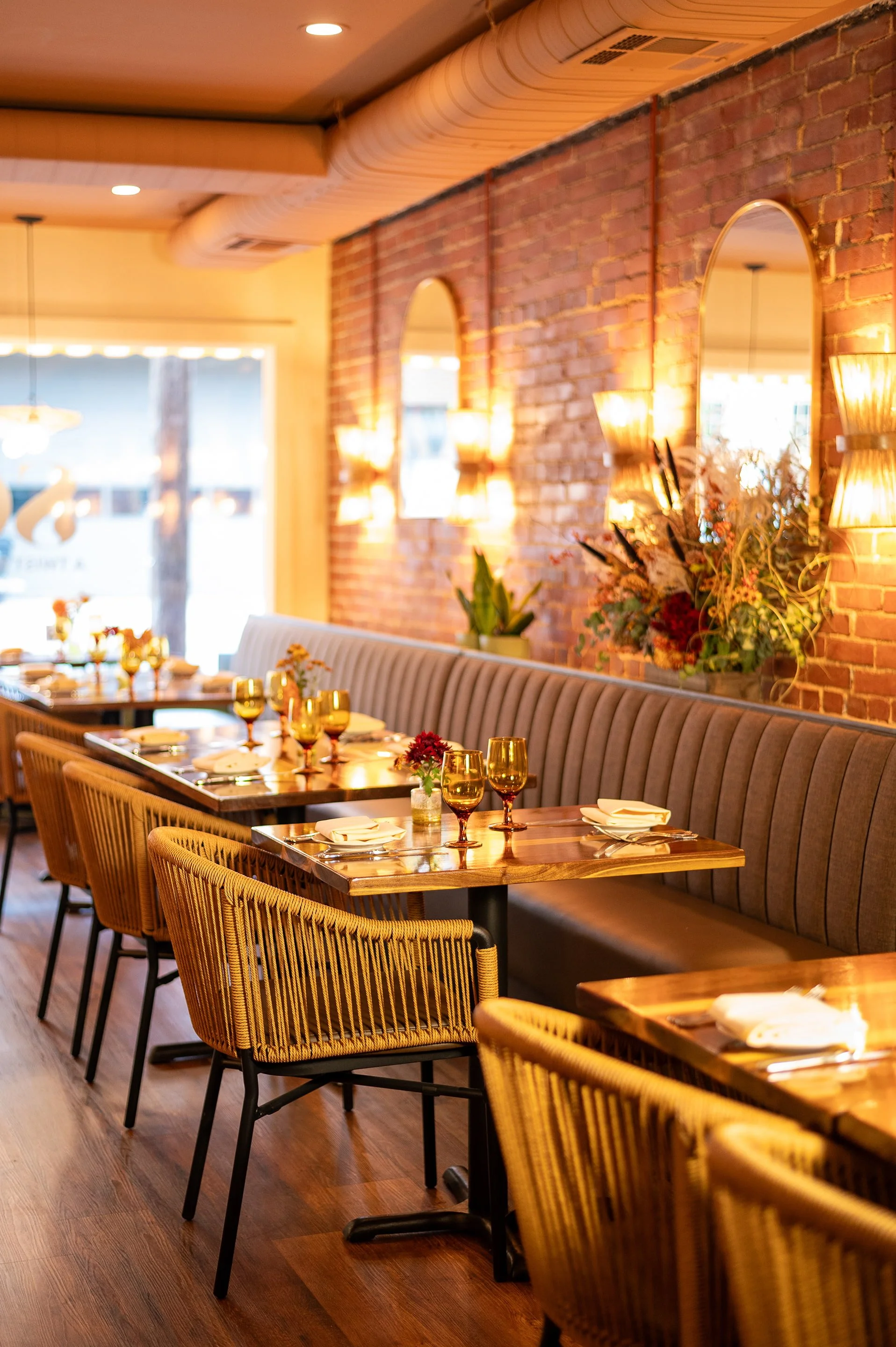 Upscale dining room at Bistro SOJO with velvet banquette seating, exposed brick walls, and warm ambient lighting.