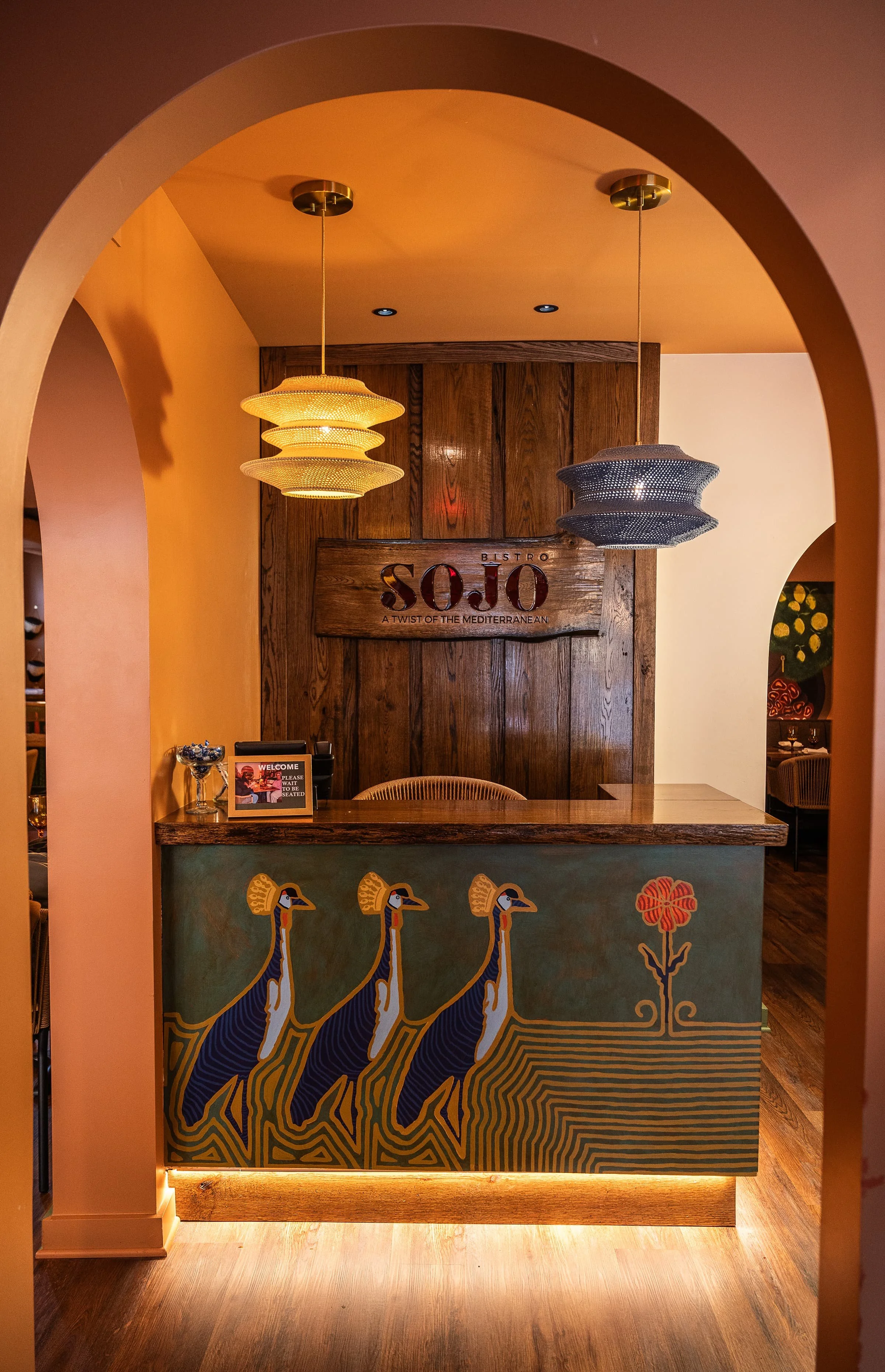 Front of SOJO Bistro with arched doorway and hanging lights over the front desk.