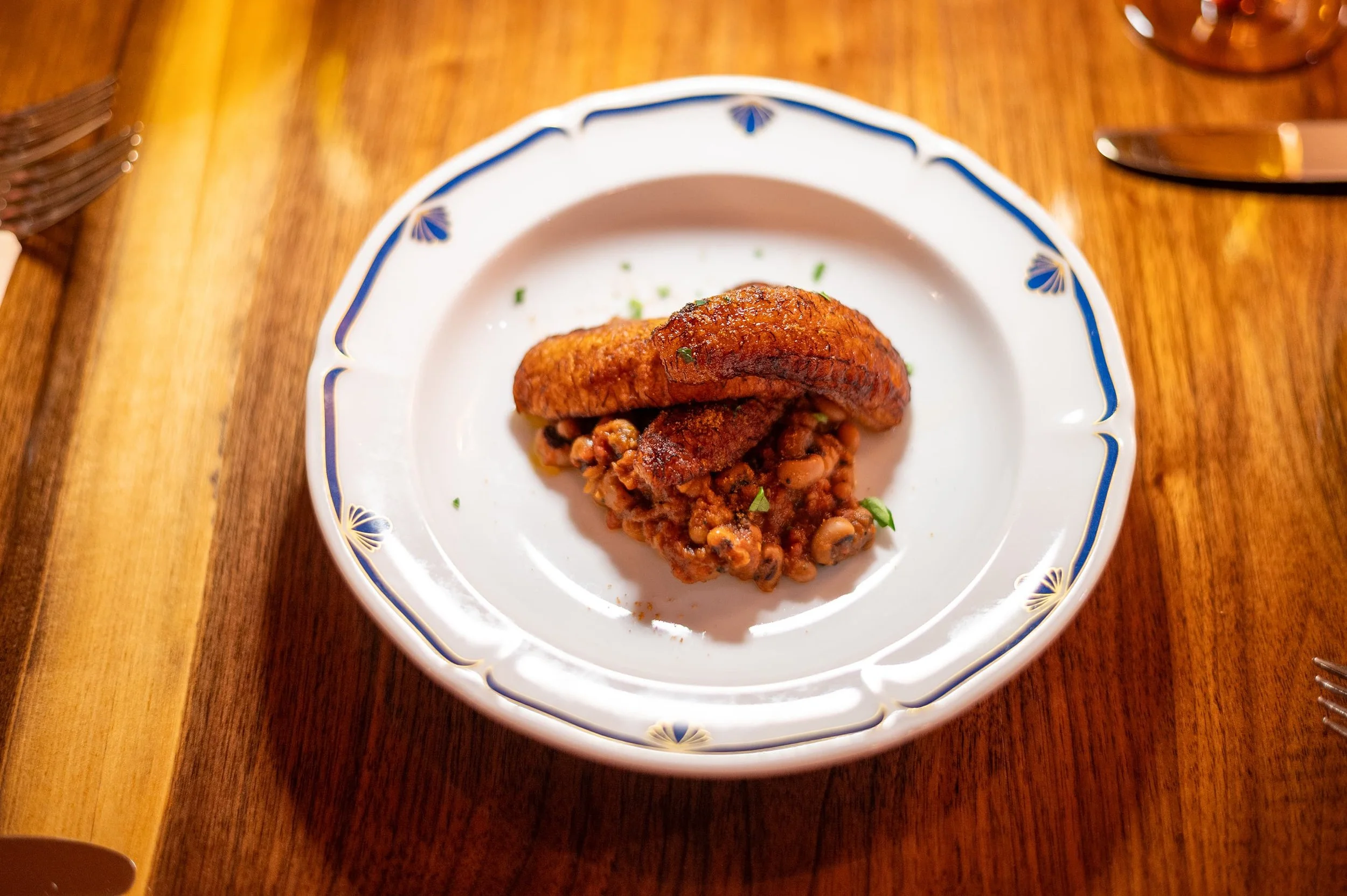 Plantain dish on a decorative blue and white china plate on a wooden table.