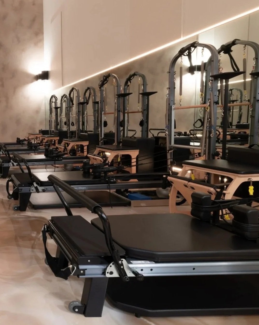 Pilates reformer machines in a modern fitness studio.