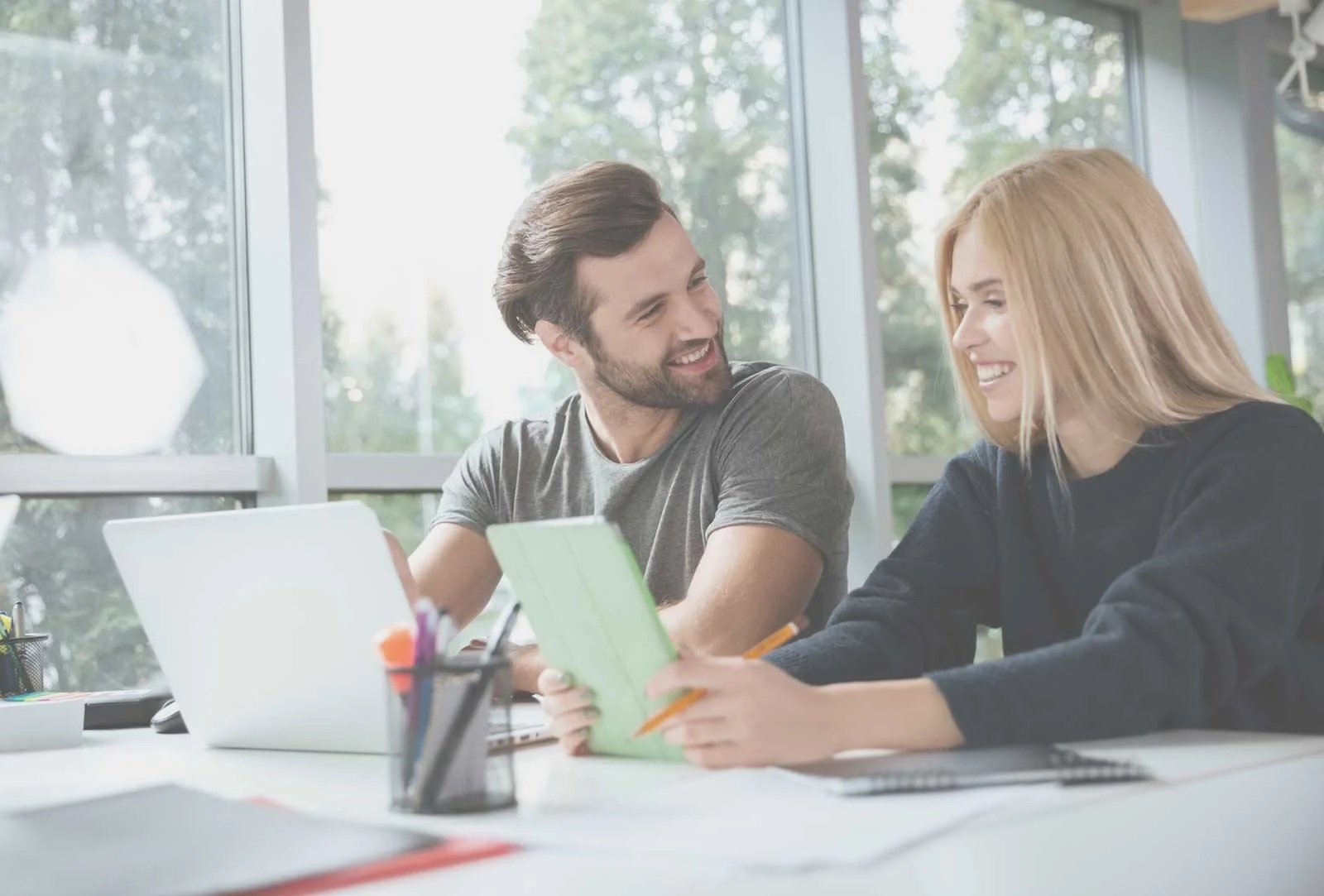 smiling-young-colleagues-sitting-office-coworking.jpg