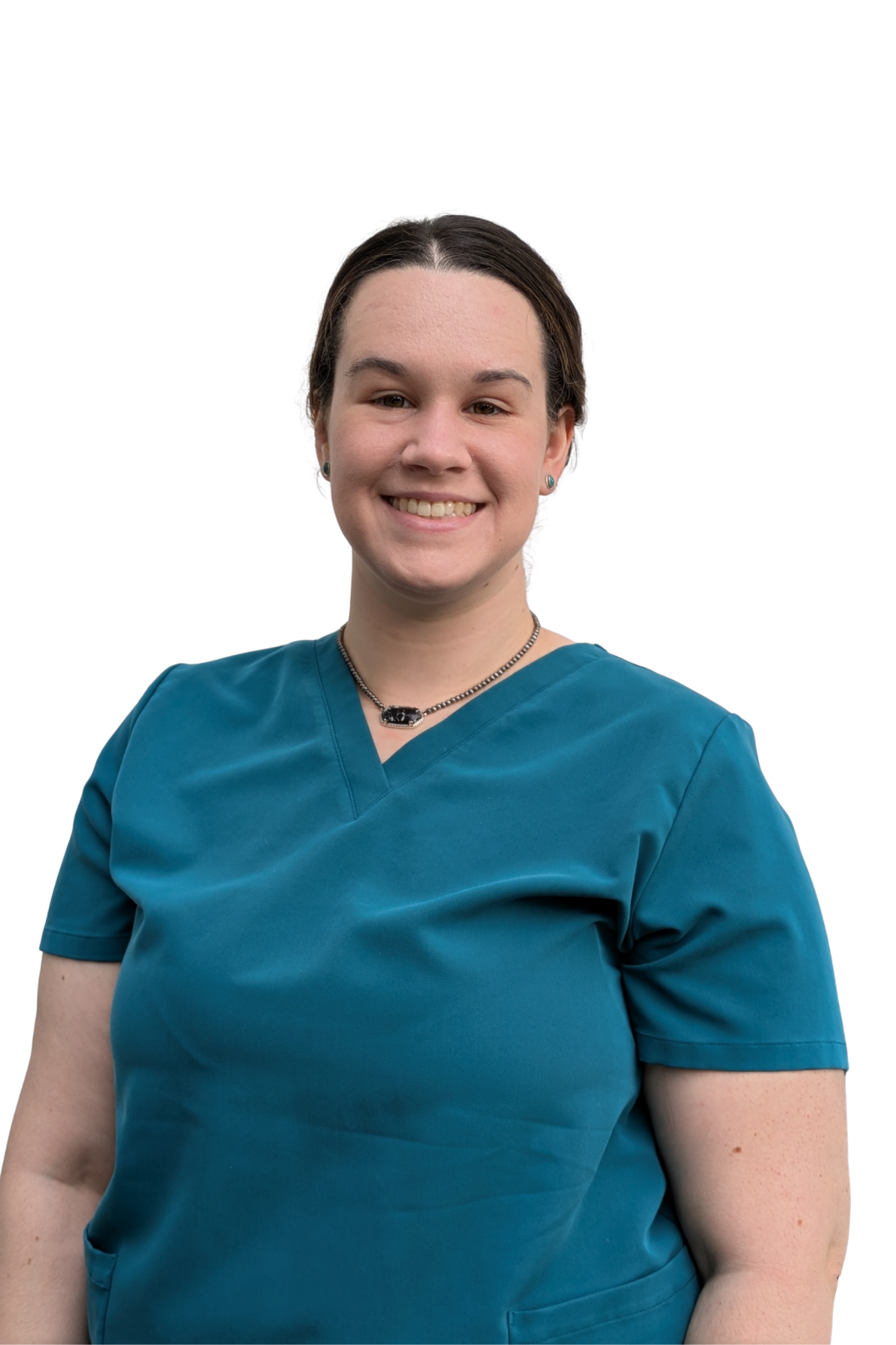 A woman with dark hair in a bun, wearing teal medical scrubs, earrings, and a necklace, smiling against a white background.