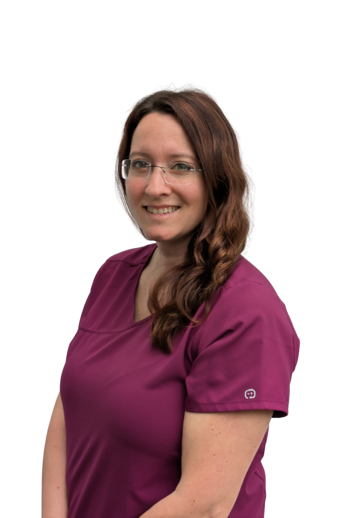 A woman with long brown hair and glasses wearing a maroon medical scrubs, smiling, against a plain white background.