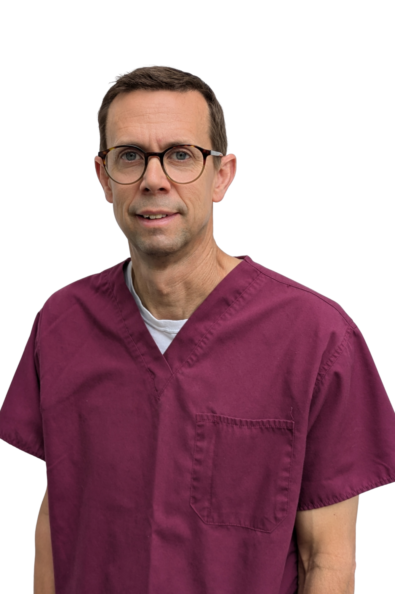 A male healthcare professional wearing glasses and a maroon scrub top, standing against a plain white background.