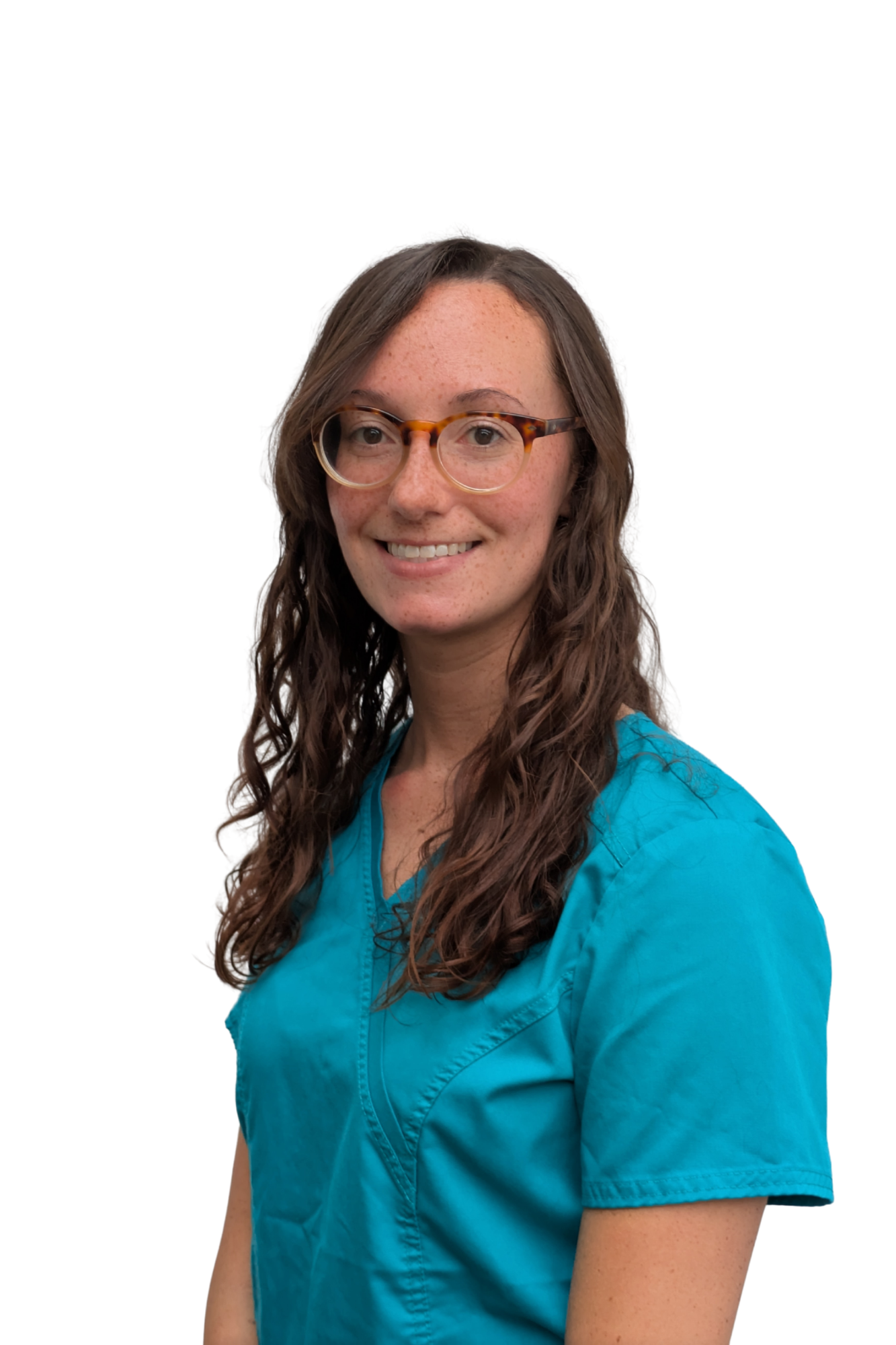 Portrait of a woman with long curly brown hair and glasses, wearing a blue medical scrub top, smiling against a white background.