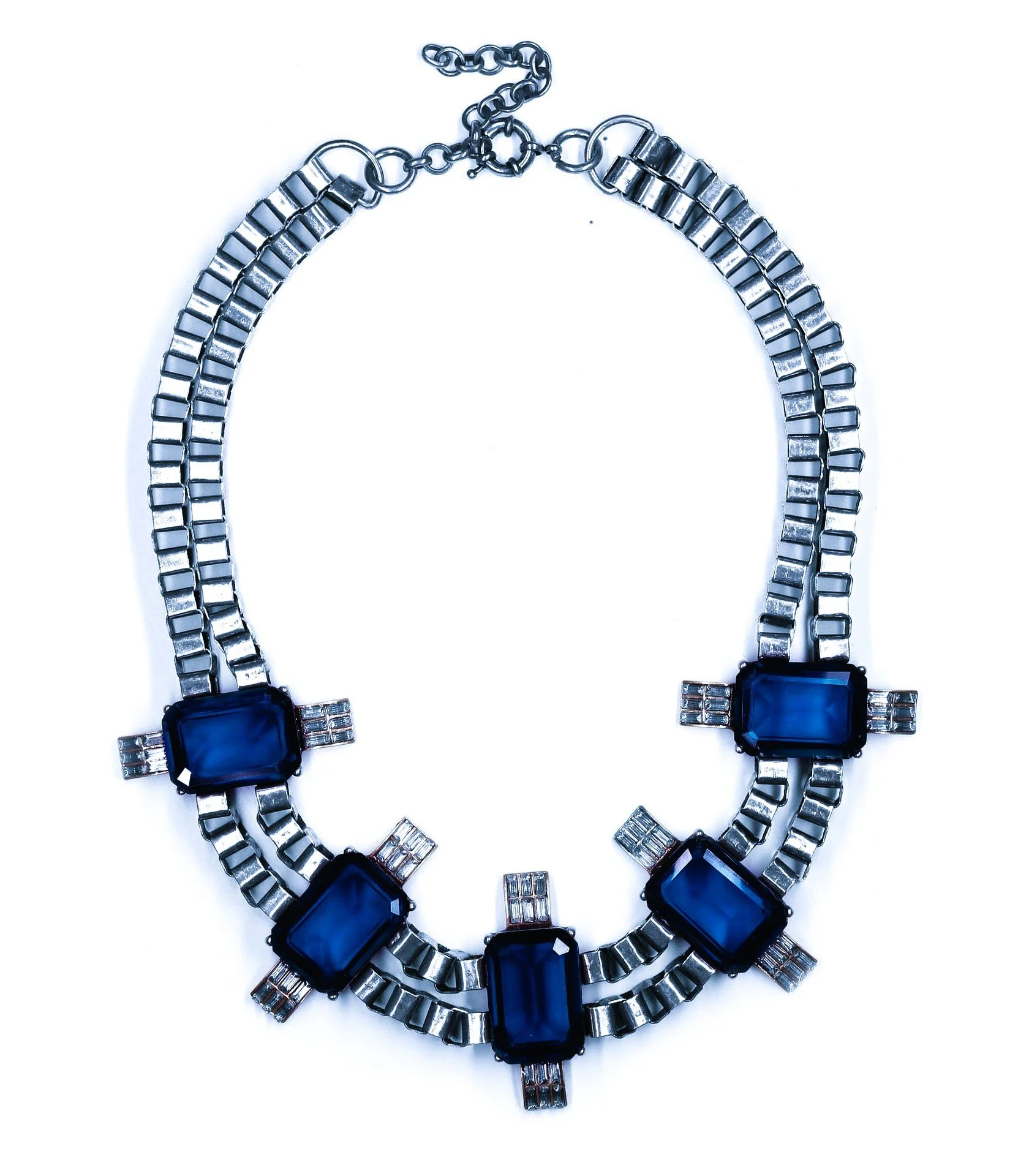 Silver necklace with blue stones and geometric design on a white background.