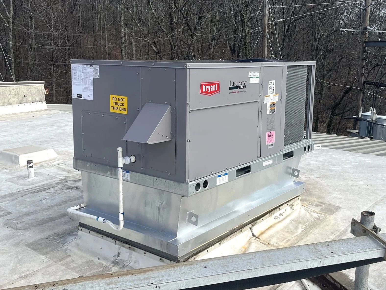 Commercial HVAC rooftop unit installed on a building roof. Connected to ductwork and electrical systems. Access heating and air conditioning, Birmingham, AL.