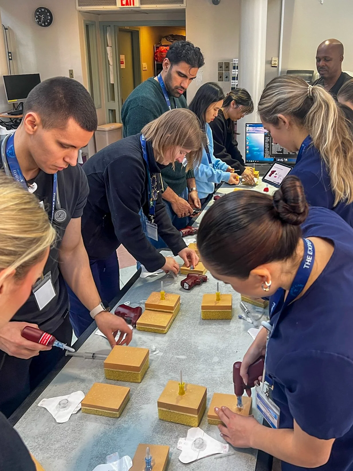 Nurses practice IV and vascular access skills on task trainers during hands-on simulation training.