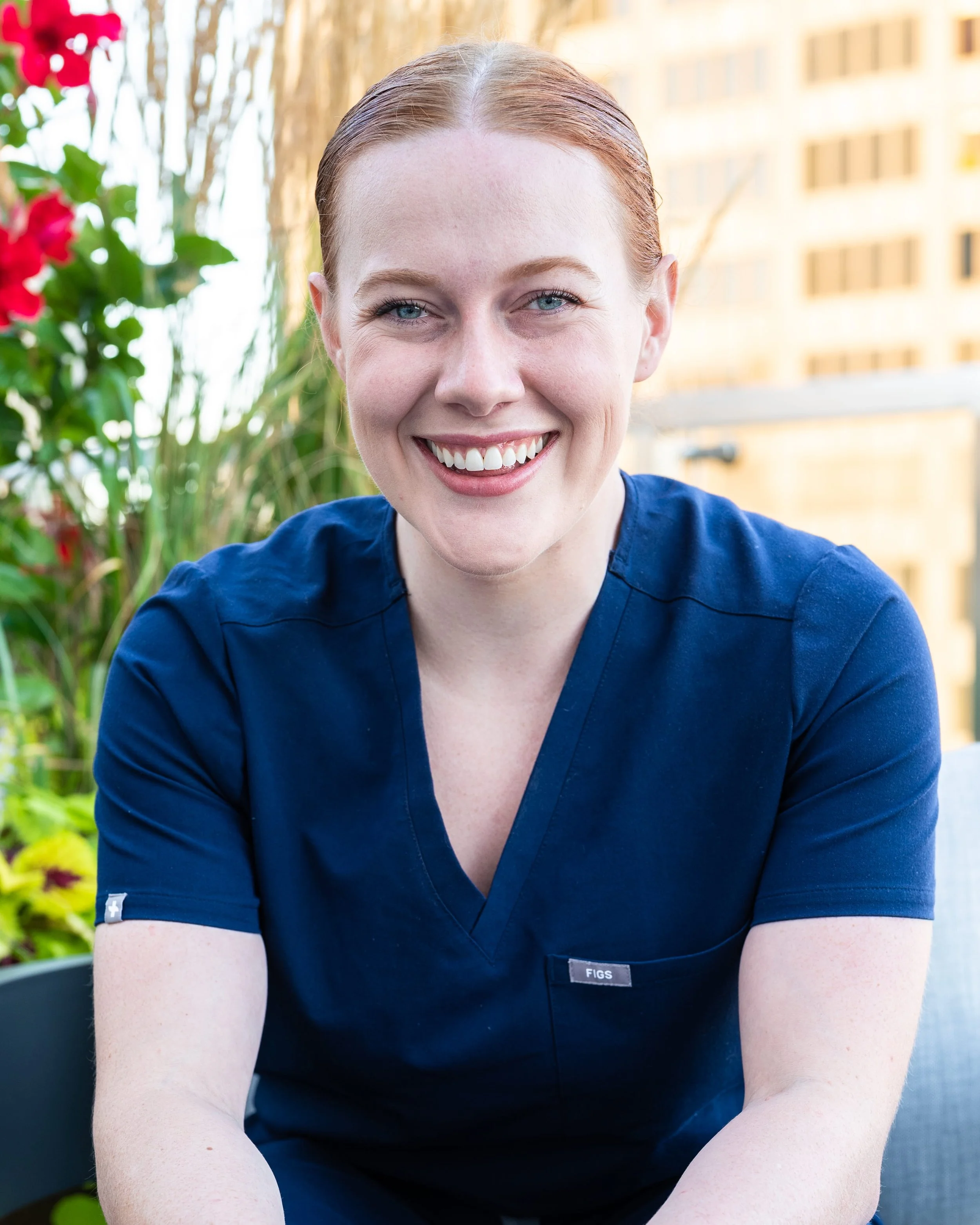 Anna Jobe, CRNA, poses for a headshot, co-founder of Confident Care Academy, with city skyline behind her.