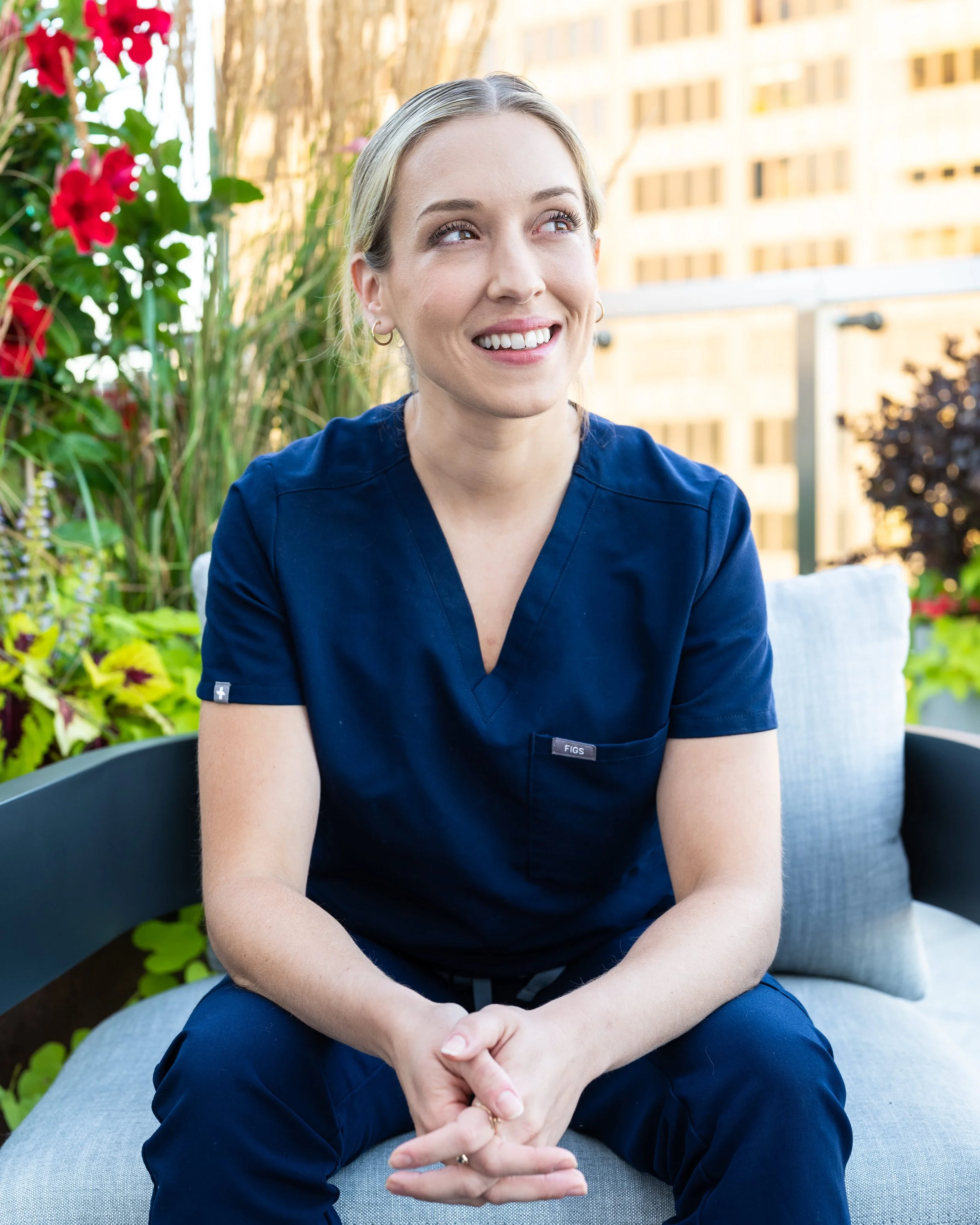 Chrissy Massaro, CRNA, co-founder of Confident Care Academy, smiling outdoors on a rooftop terrace.