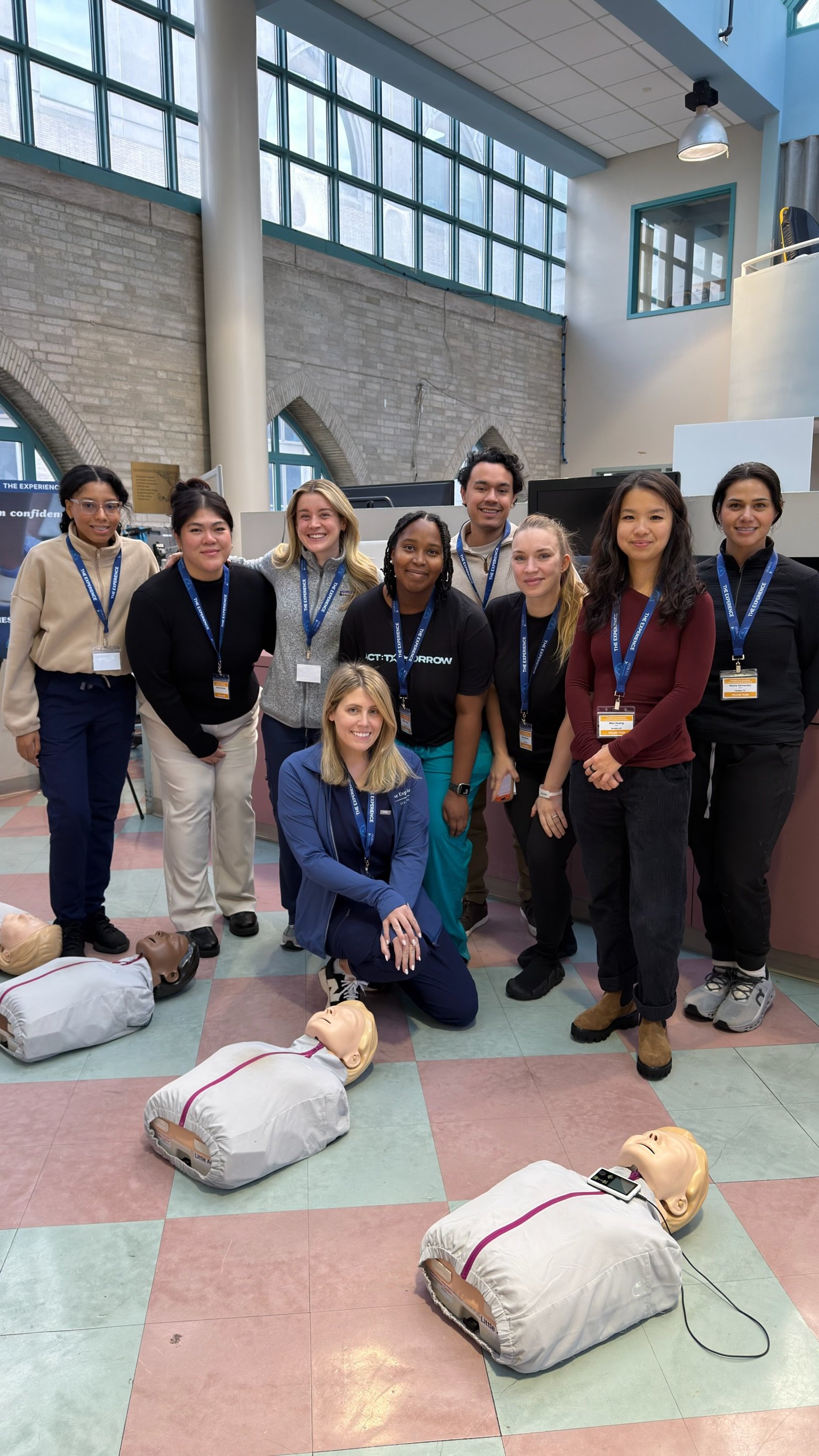 A group of clinicians pose together after completing CPR training stations at the Confident Care Experience.