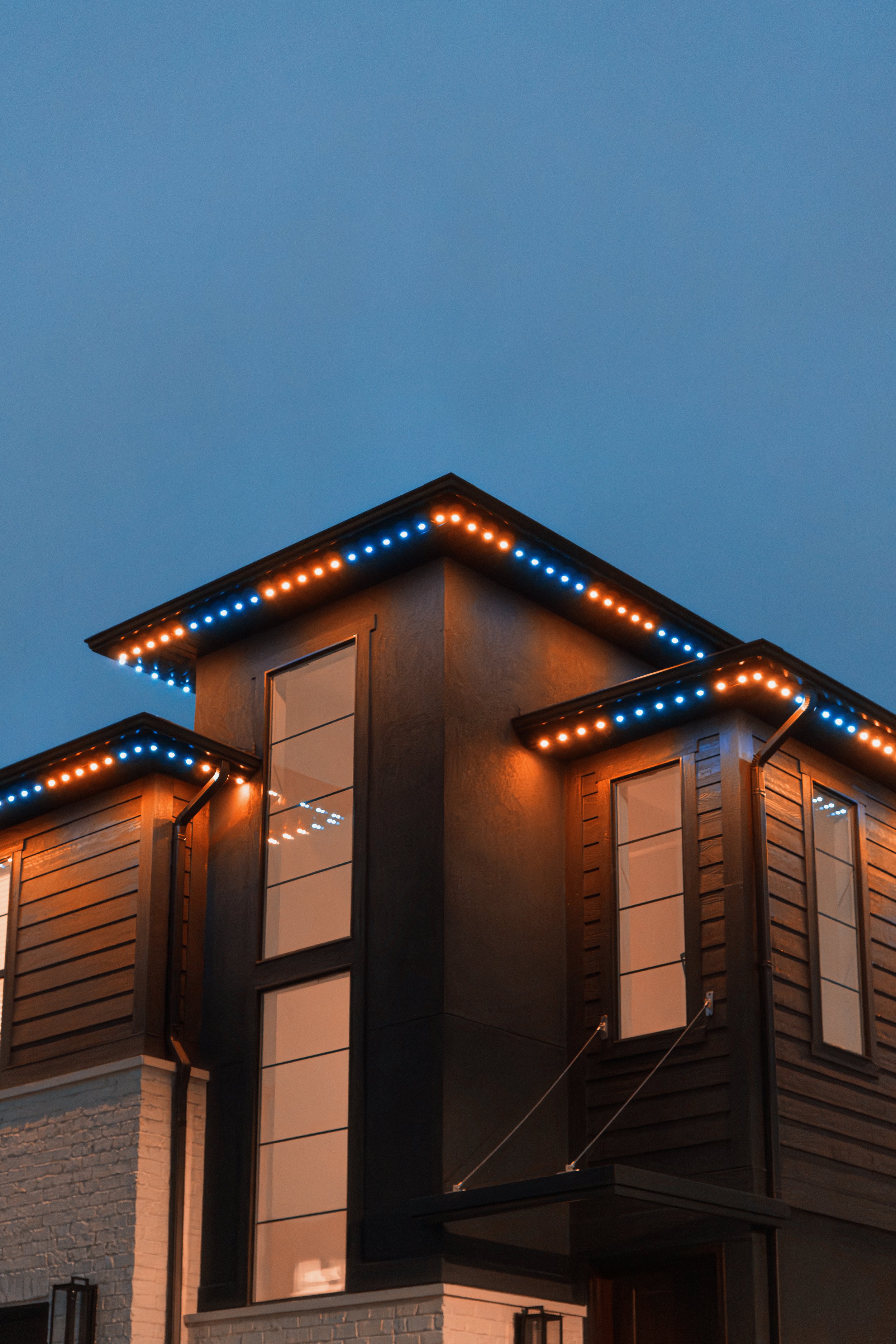 Modern house with large windows and JellyFish Lighting along the roof at dusk.