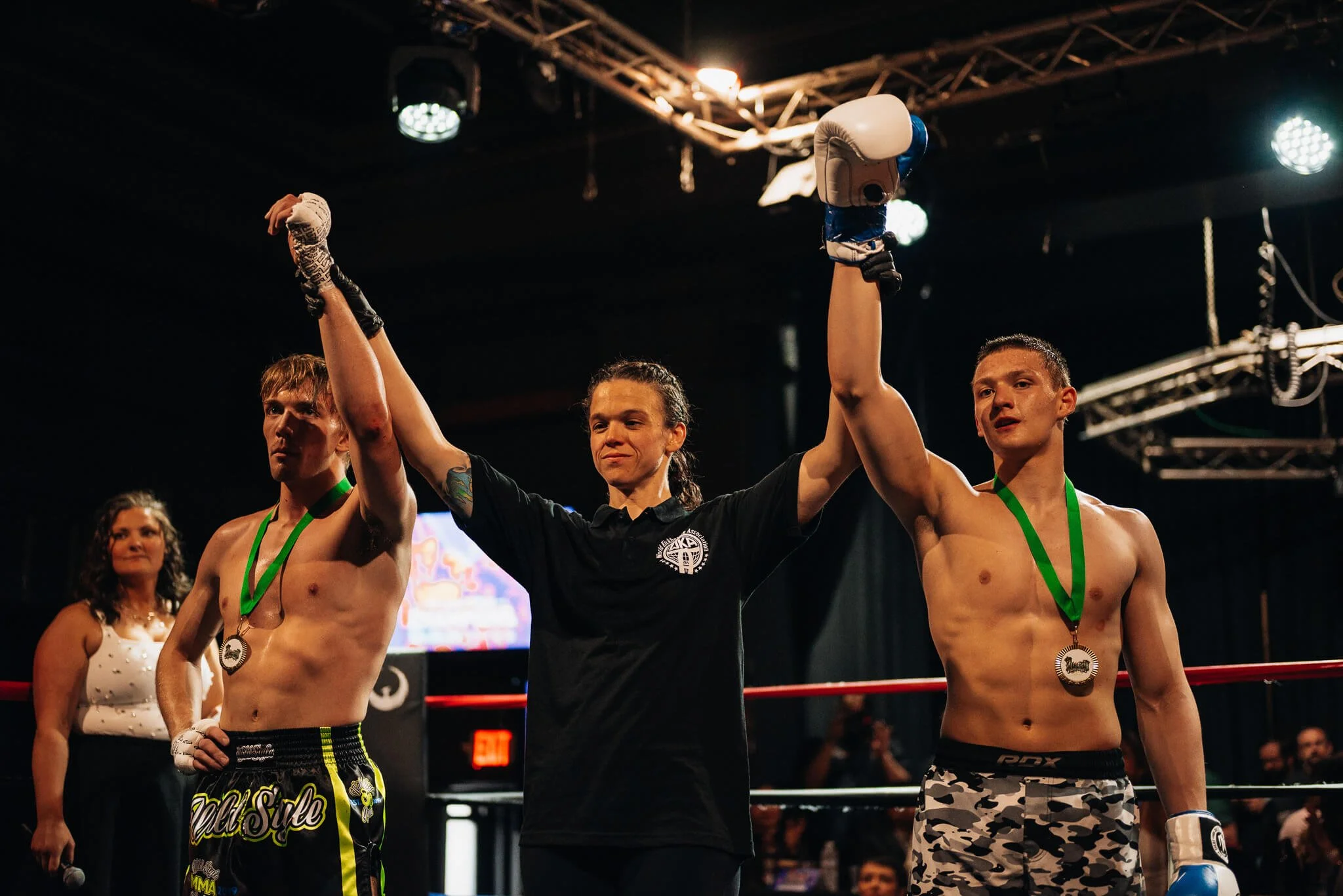 A referee raises a fighter’s hand after a Muay Thai match at All City Fight Night.