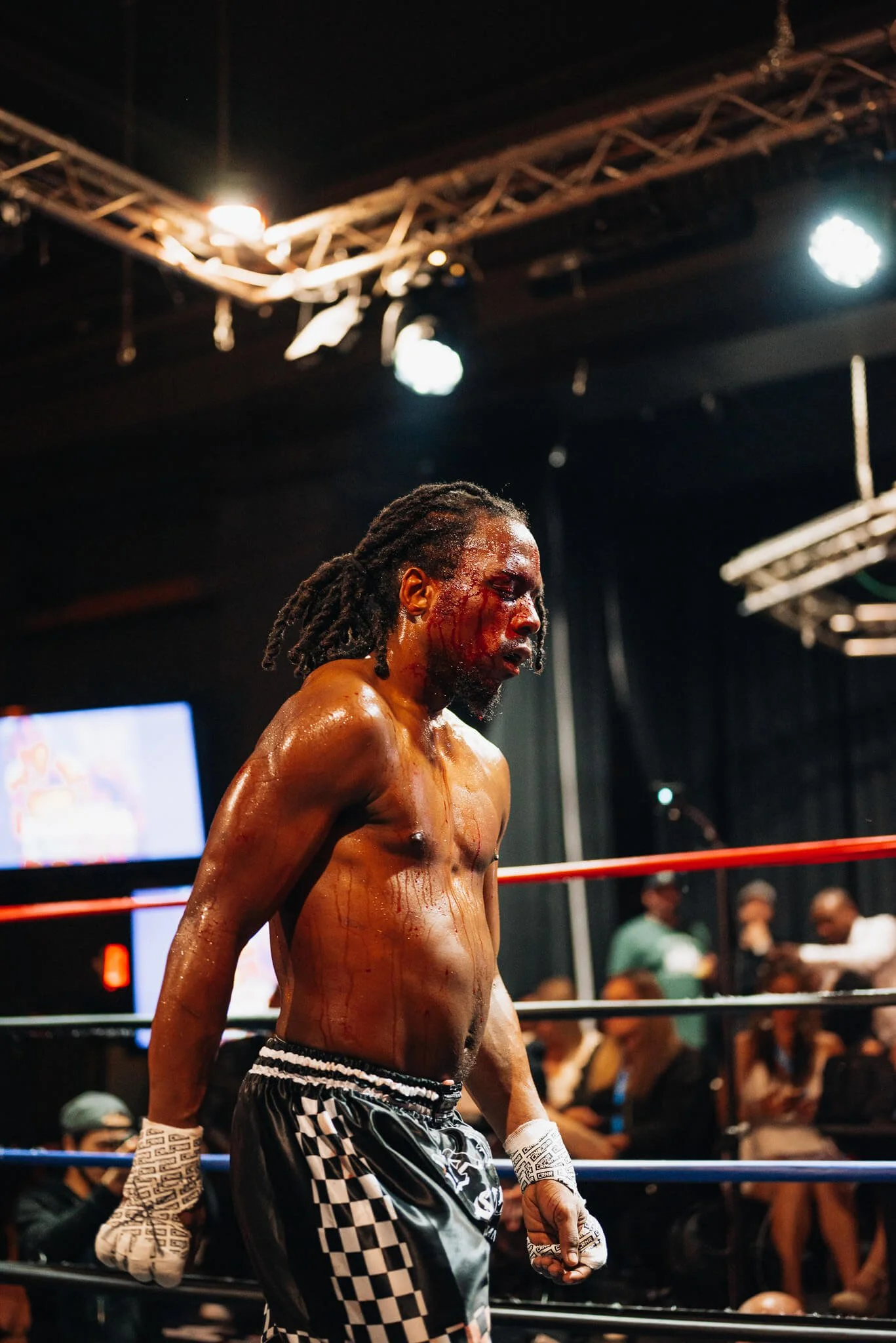 Kickboxing fighter with bloodied face standing in ring during All City Fight Night in Everett Washington