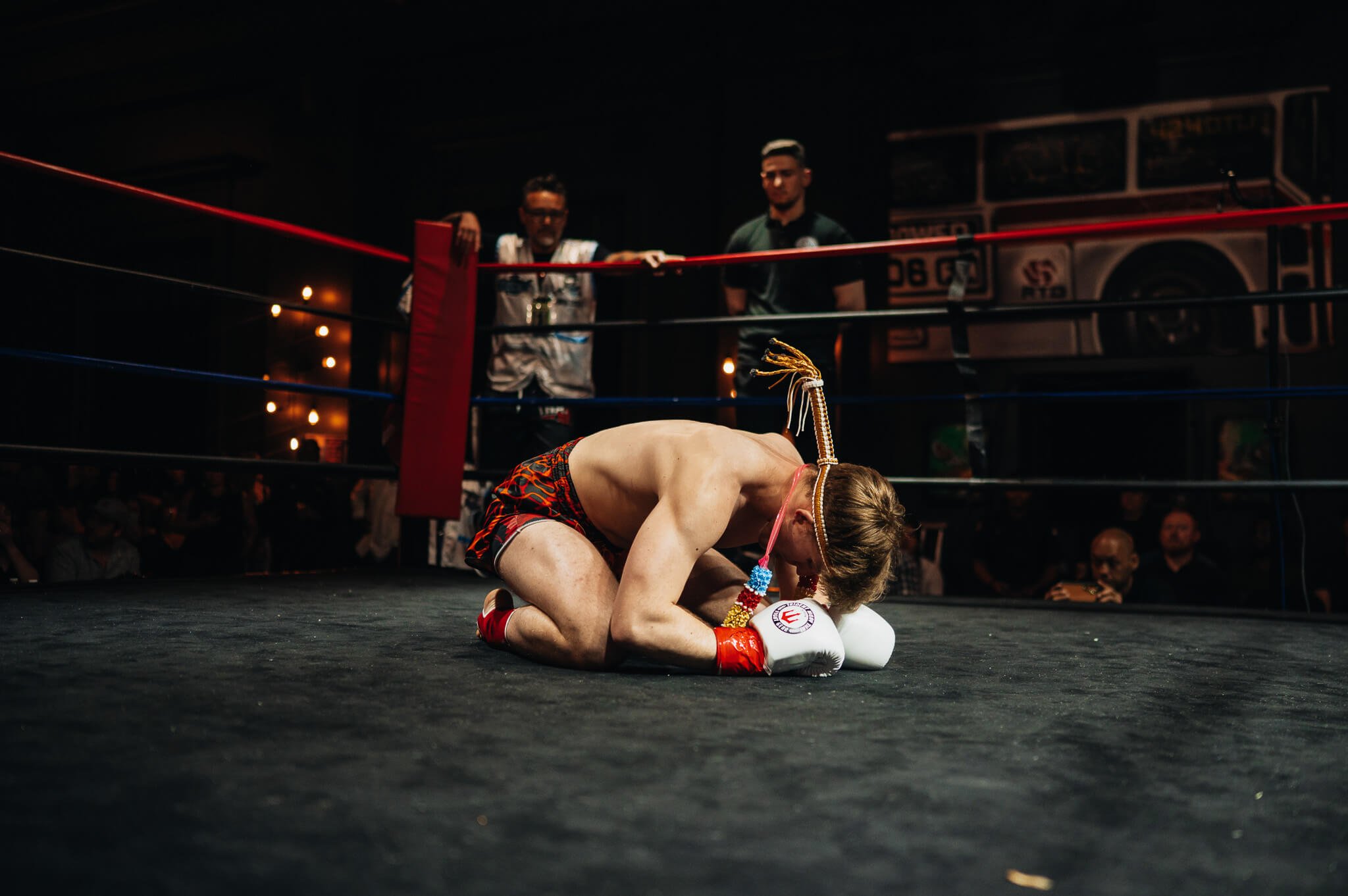 A Muay Thai fighter performs a traditional wai kru ritual in the ring before a match at All City Fight Night in Everett, Washington.