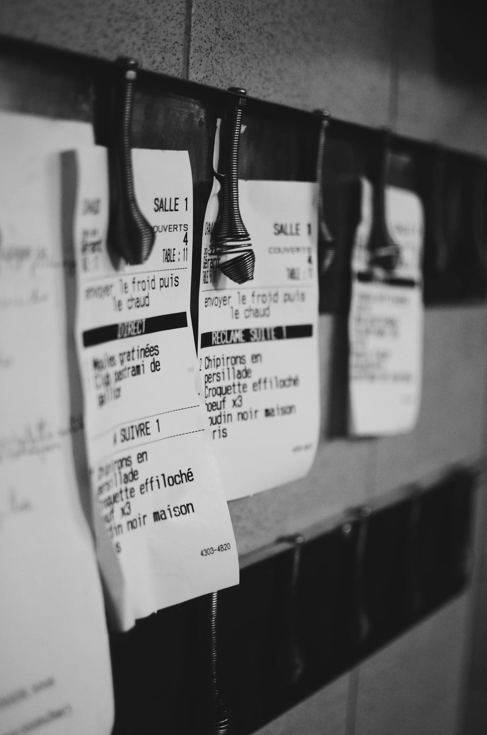black and white image of receipts pinned to a board