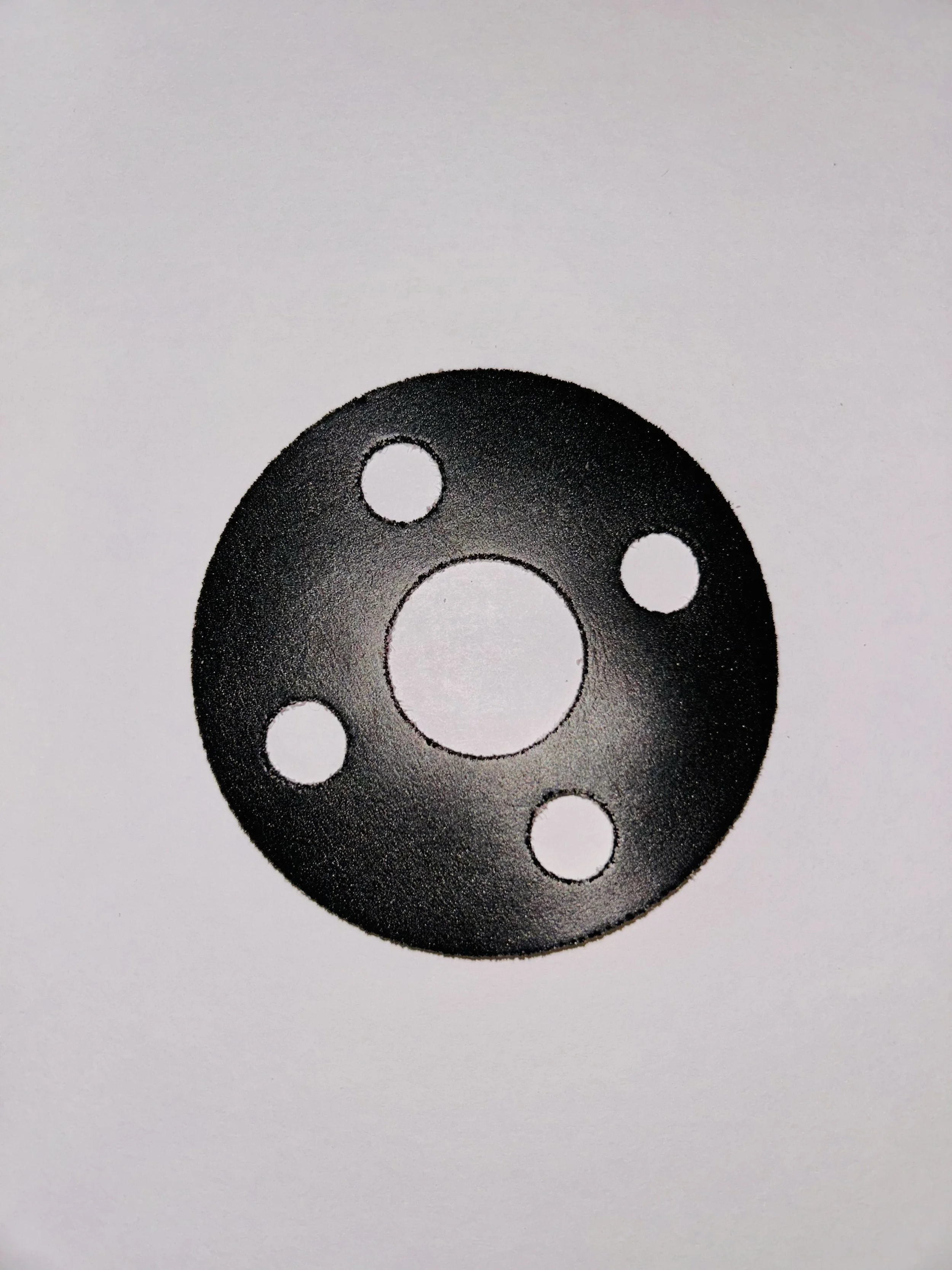 A circular foam gasket with five holes, placed on a white background.