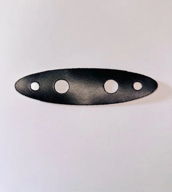 Close-up of a black SBR foam cleat gasket with five holes of varying sizes on a white background.