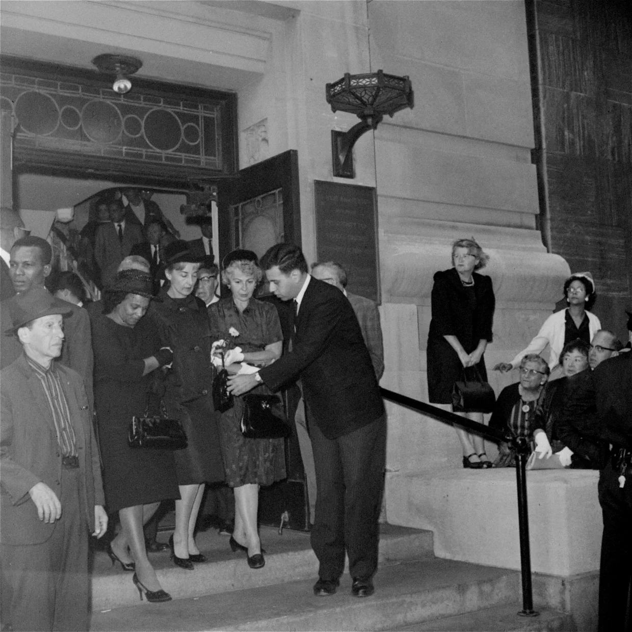 Mrs. Caroline Goodman, center, with Mrs. Fannie Chaney, mother of James E. Chaney, slain civil rights worker, left, and Mrs. Nathan Schwerner, mother of slain Michael Schwerner, are escorted from Ethical Culture Society Hall August 9, 1964, after att
