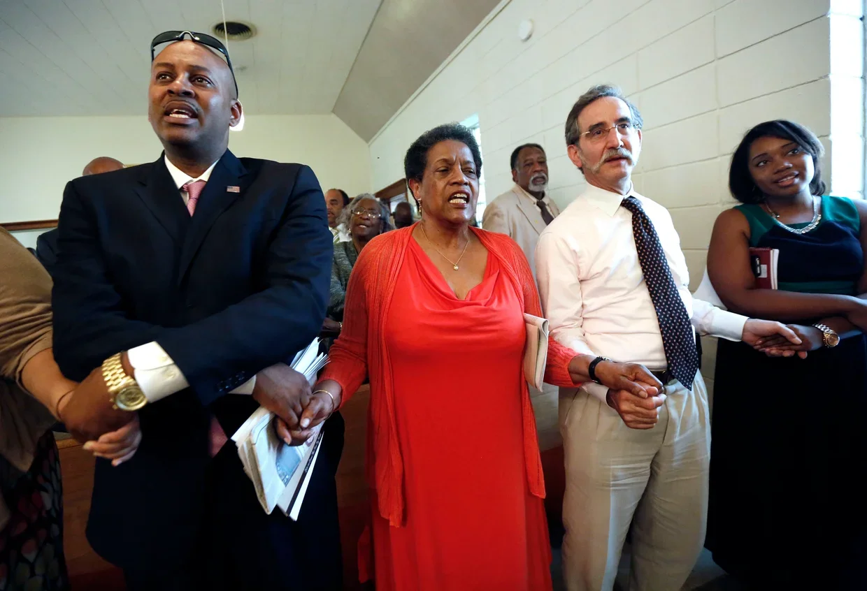 Meridian Mayor Percy Bland, left, holds hands with civil rights activist and widow of civil rights pioneer Medgar Evers, Myrlie Evers-Williams, and Dave Goodman, brother of slain civil rights worker Andrew Goodman during a ceremony at the Mt. Zion Un